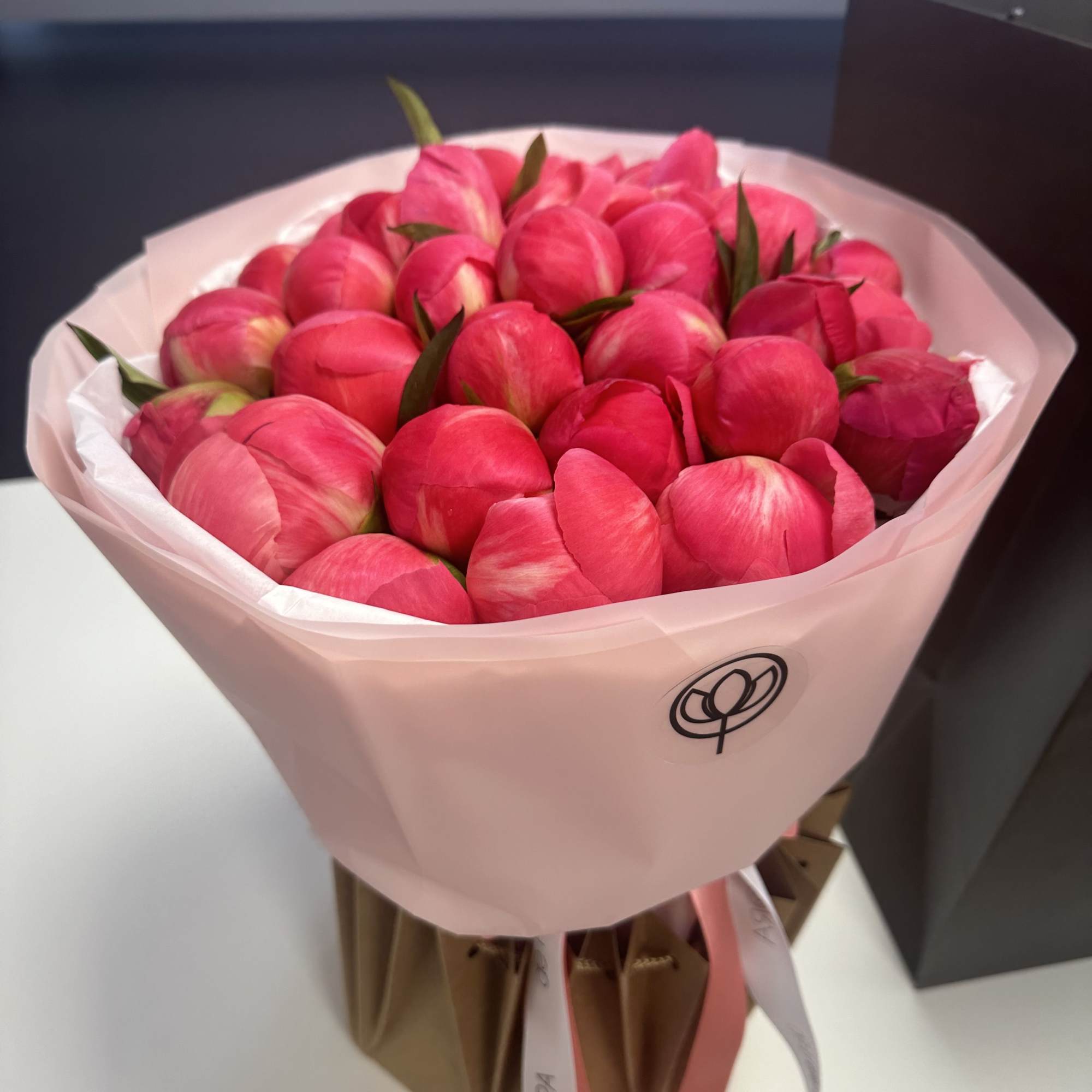 Bouquet of bright pink tulips wrapped in pale pink paper