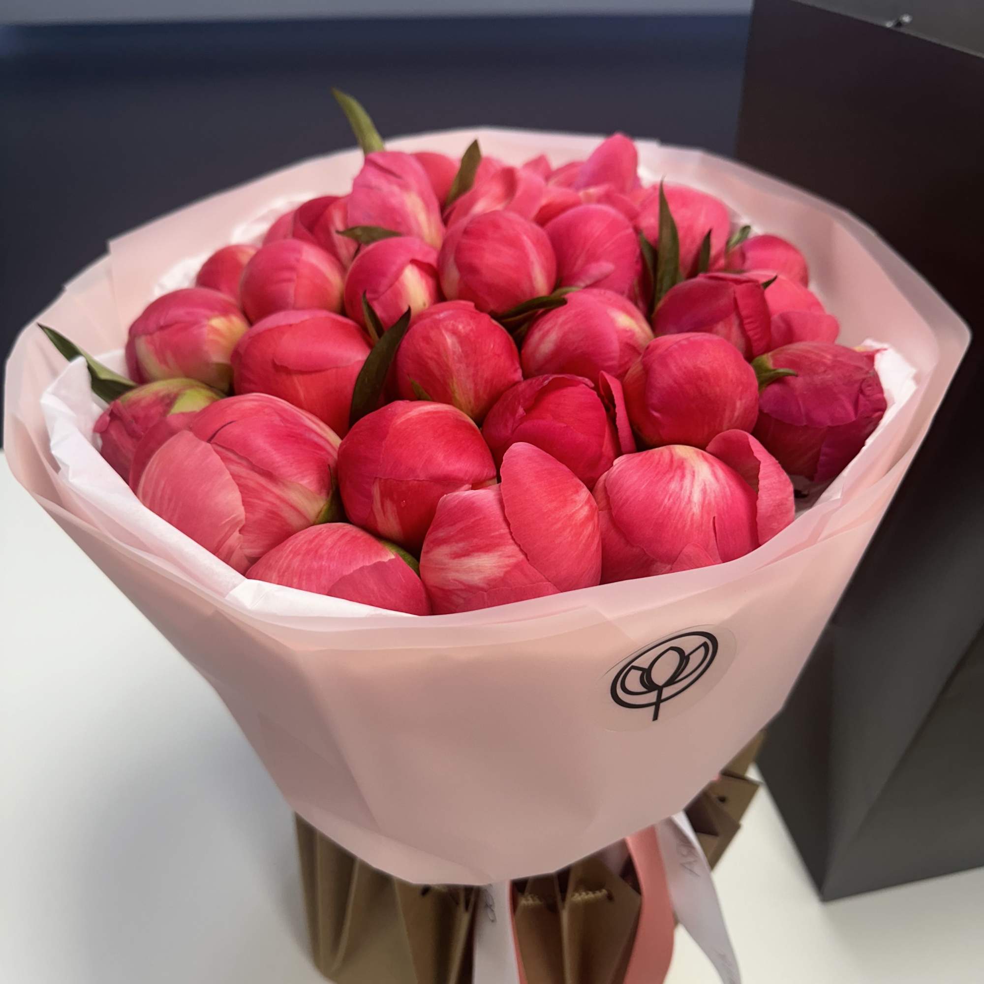 Bouquet of bright pink tulips wrapped in pale pink paper