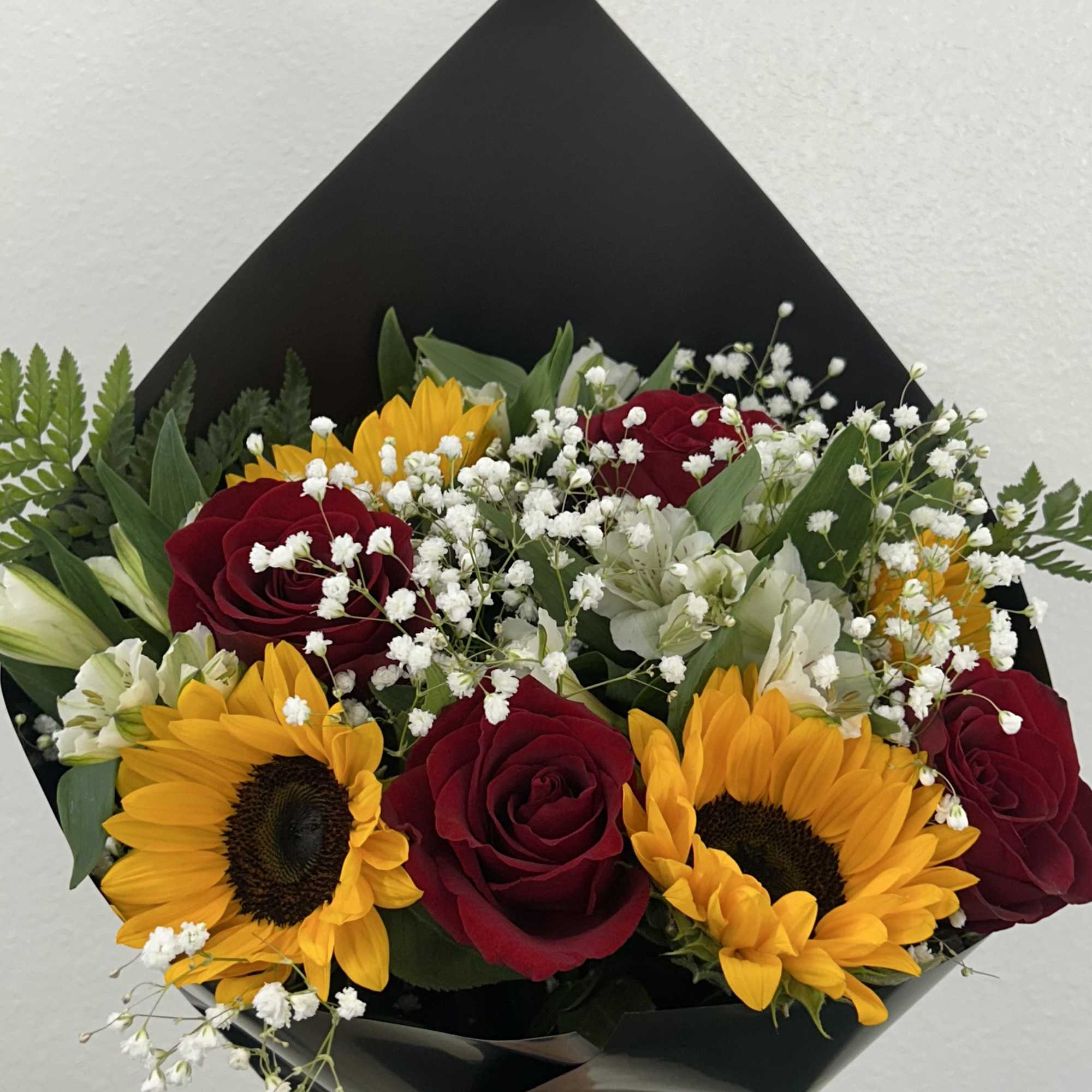 Bouquet of red roses and yellow sunflowers with white filler flowers