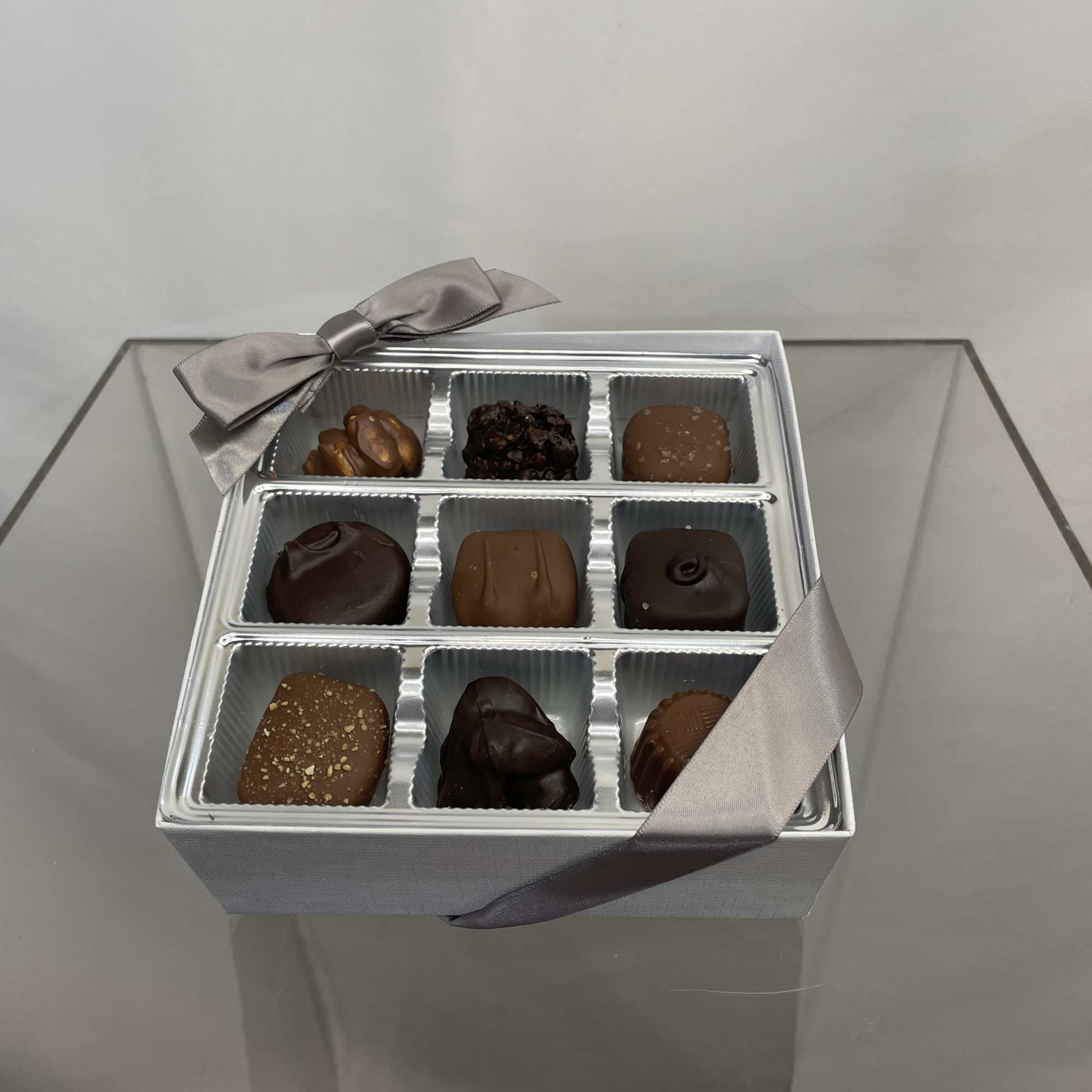 Box of assorted chocolates with a silver ribbon