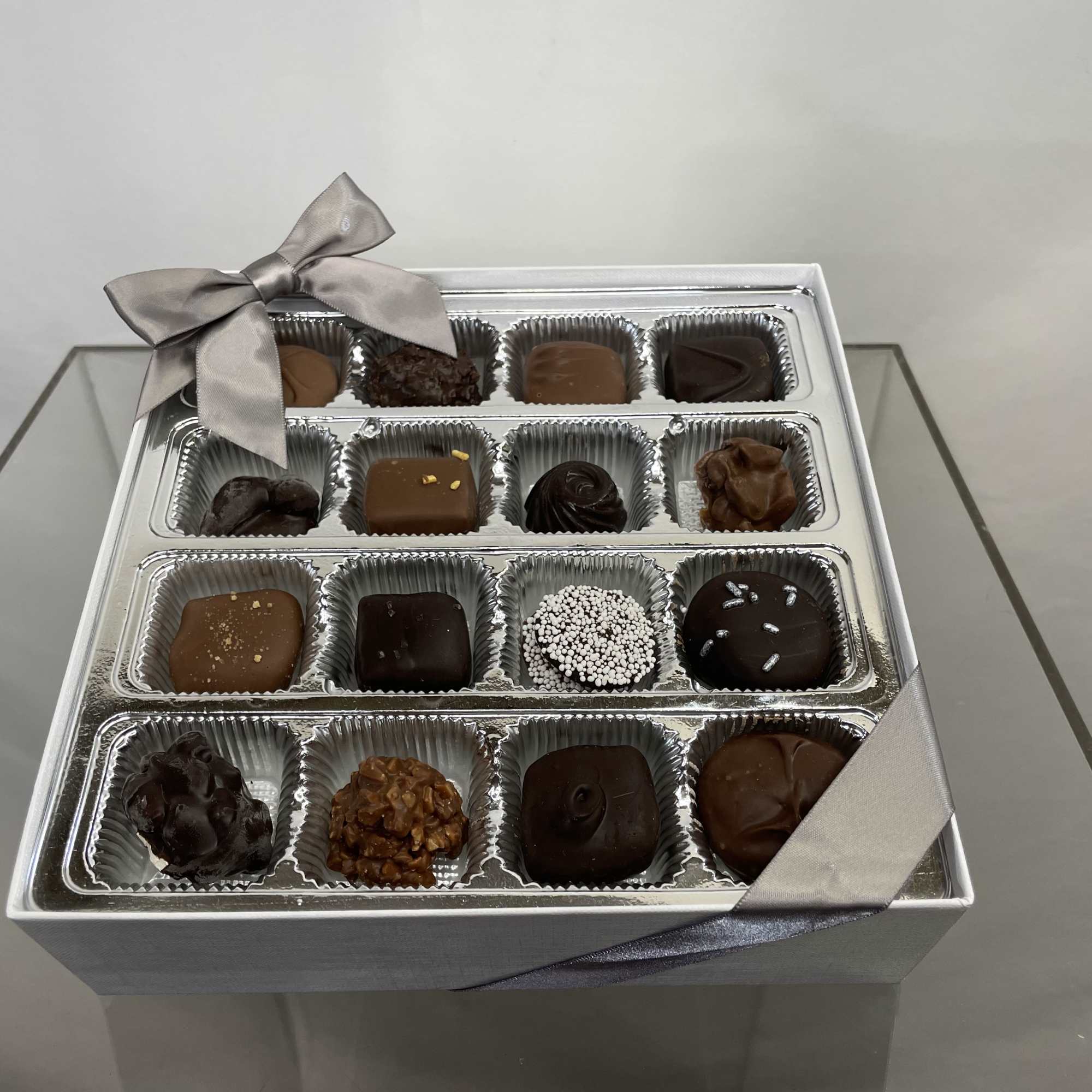 Box of assorted chocolates with a silver ribbon bow
