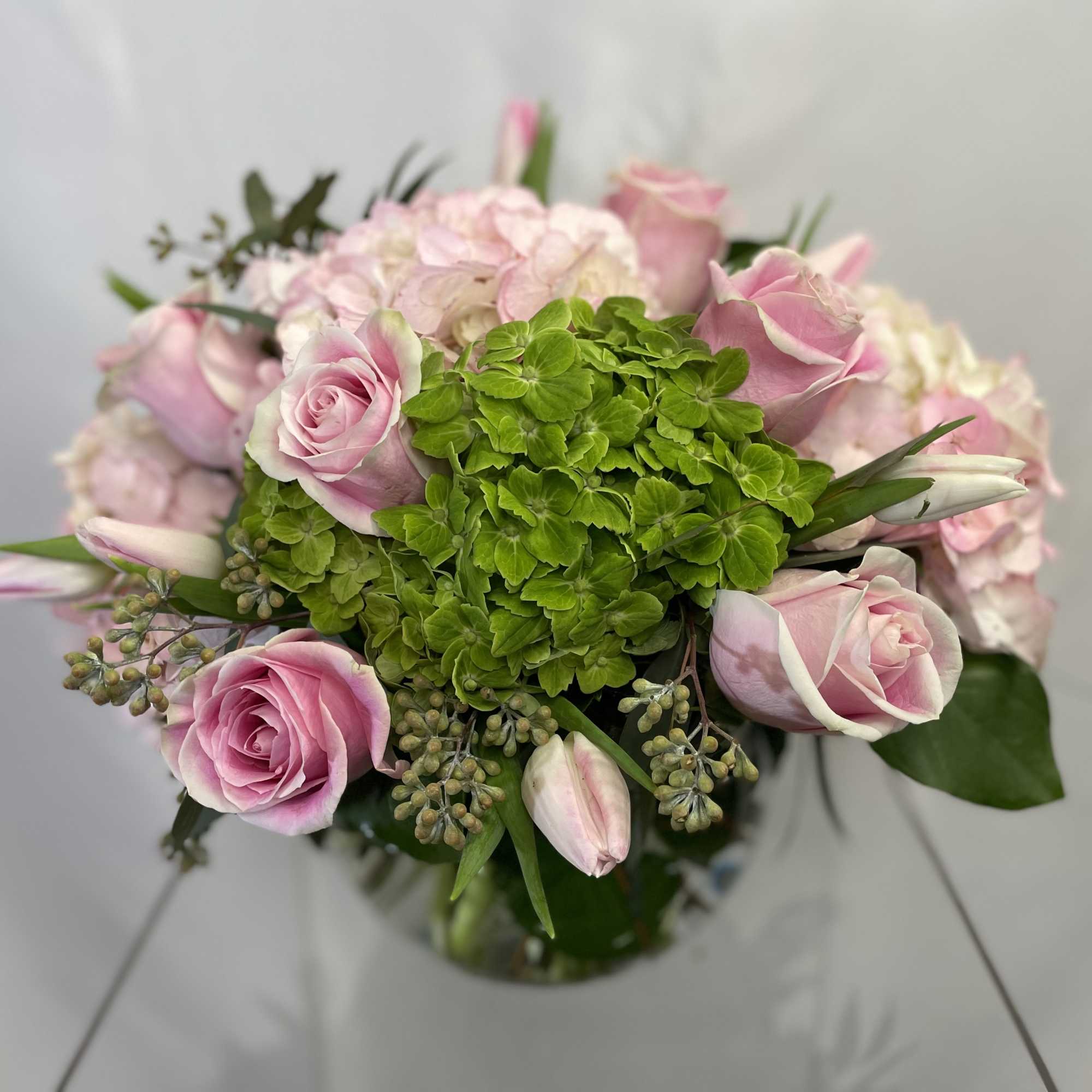 Pink roses and hydrangea bouquet with green center blooms