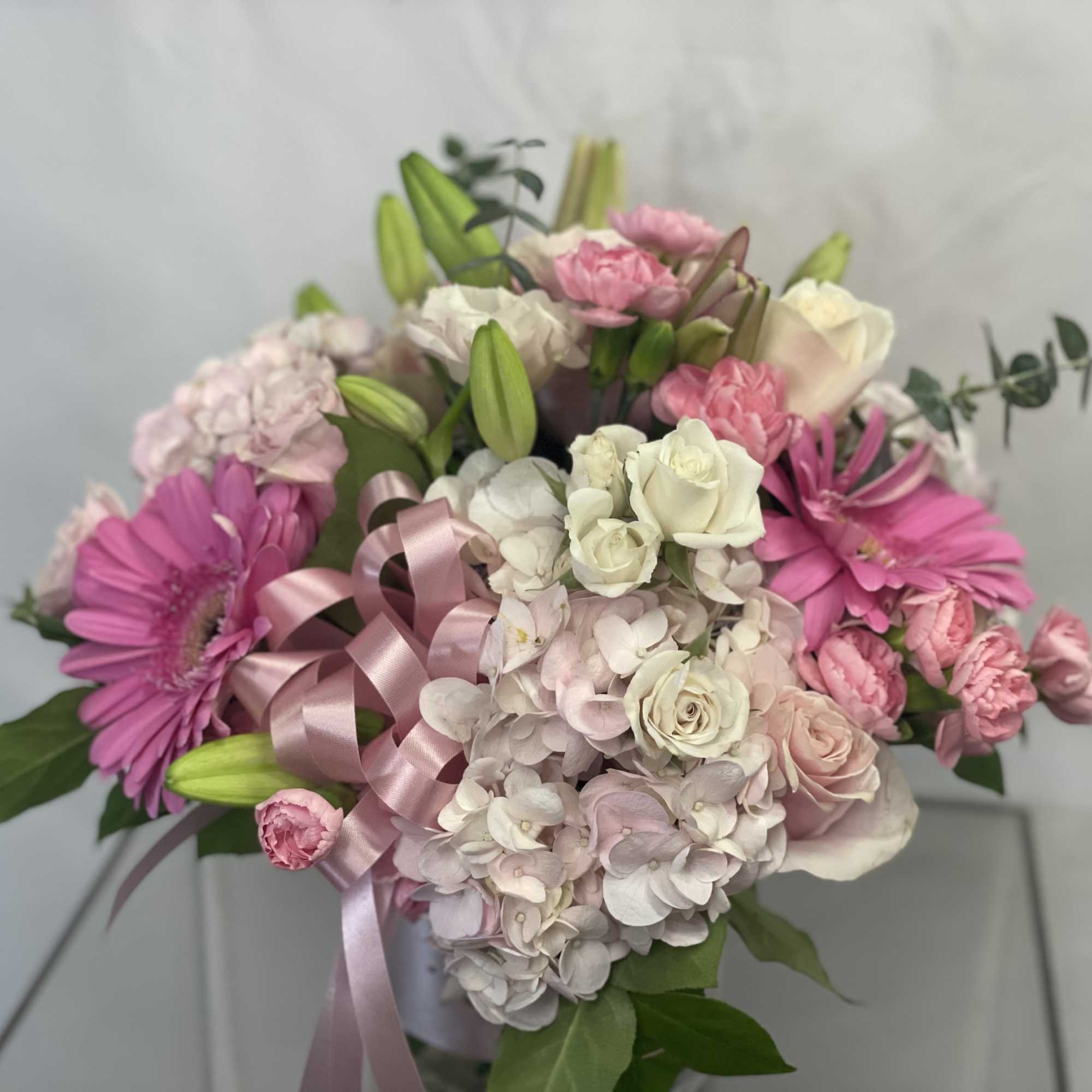 Pink and white bouquet with lilies, roses, hydrangea, and a satin ribbon