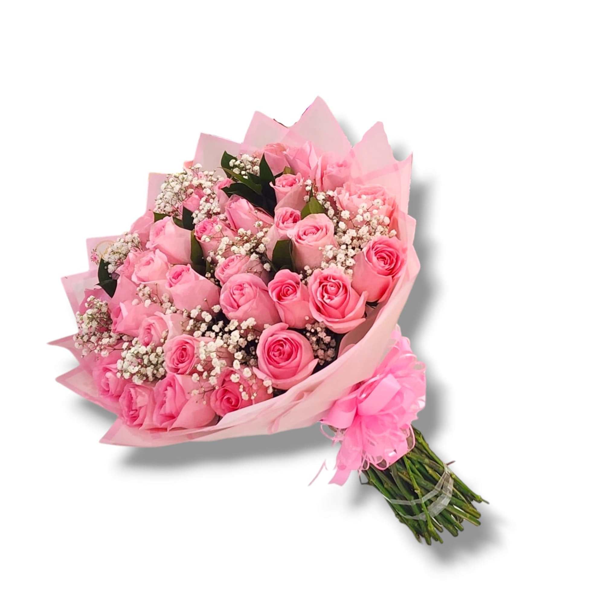 Hand-tied bouquet of pink roses with white filler flowers wrapped in pink paper and ribbon.