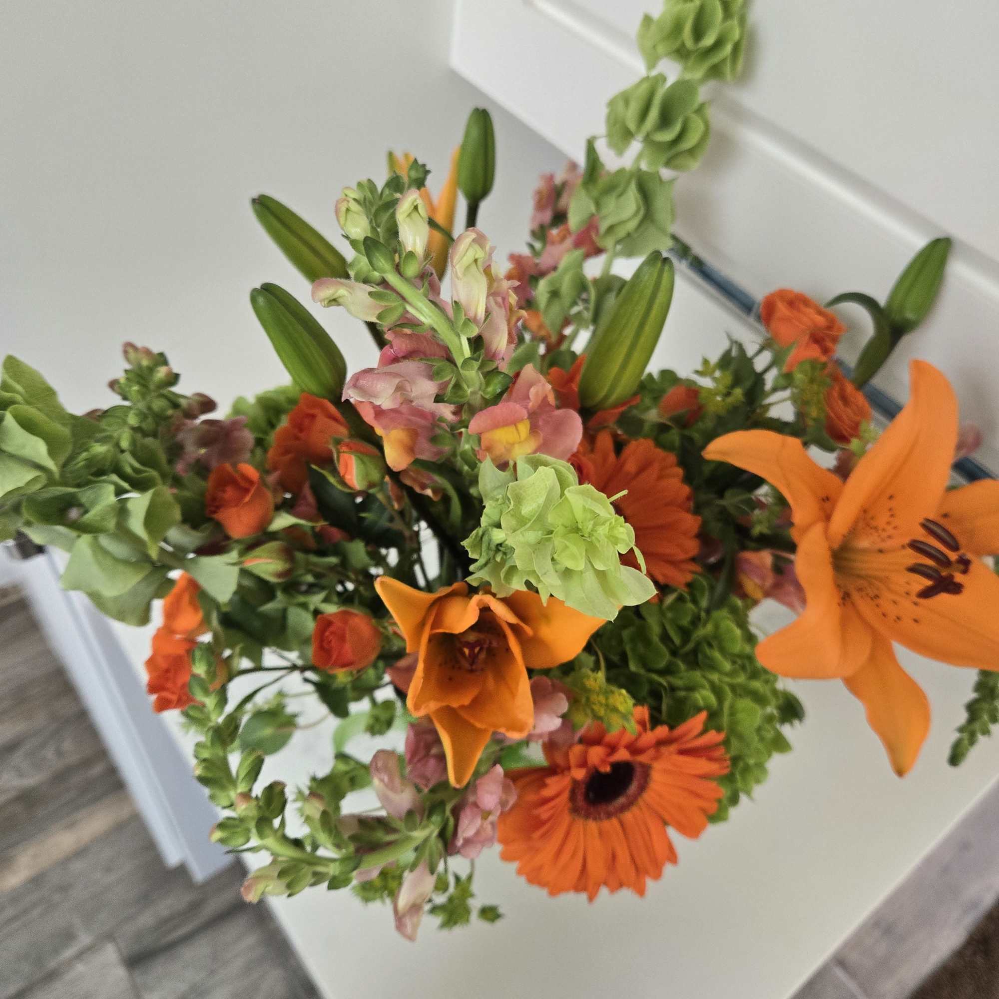 Bouquet of orange and green flowers with lilies and snapdragons