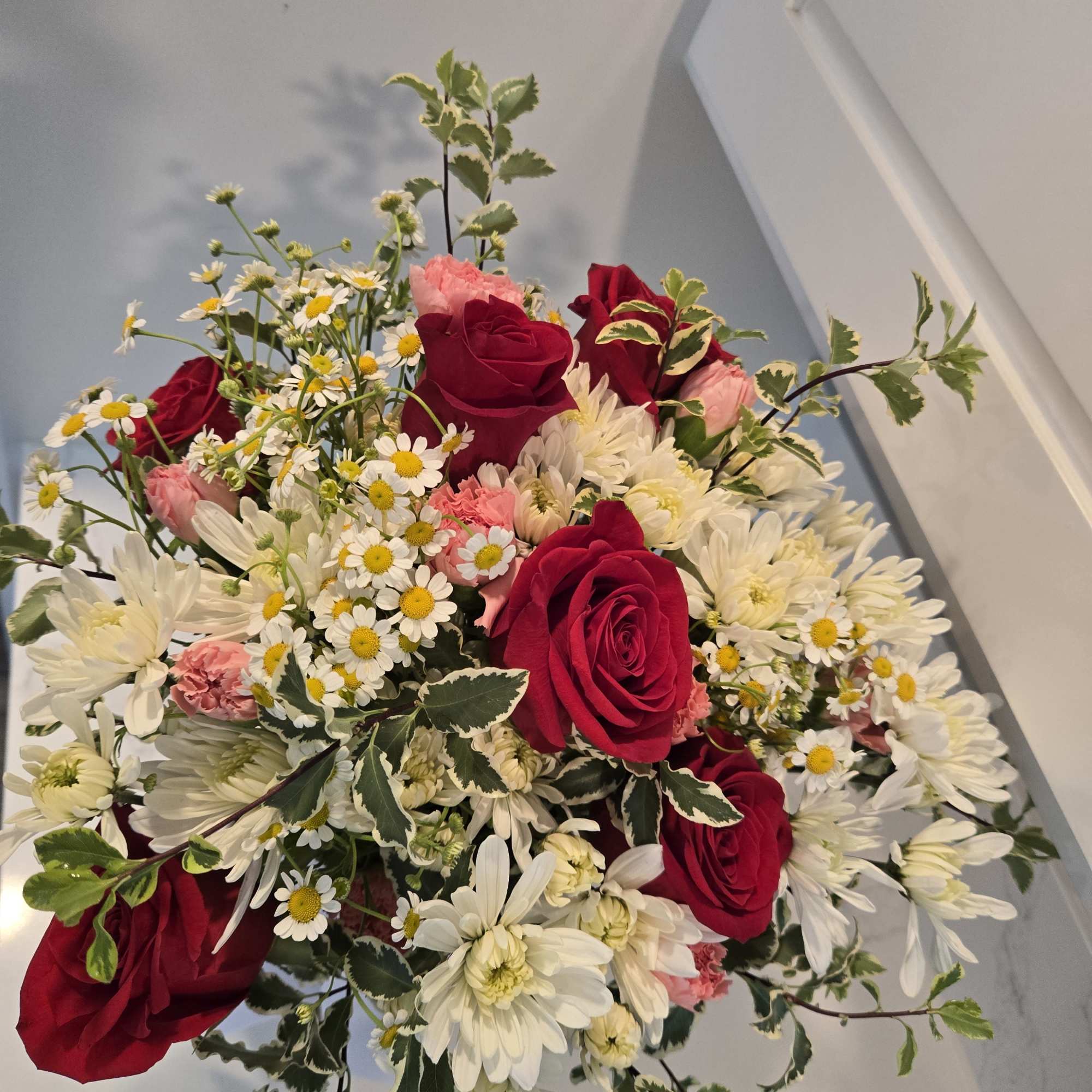 Bouquet of red roses, white daisies, and pink carnations