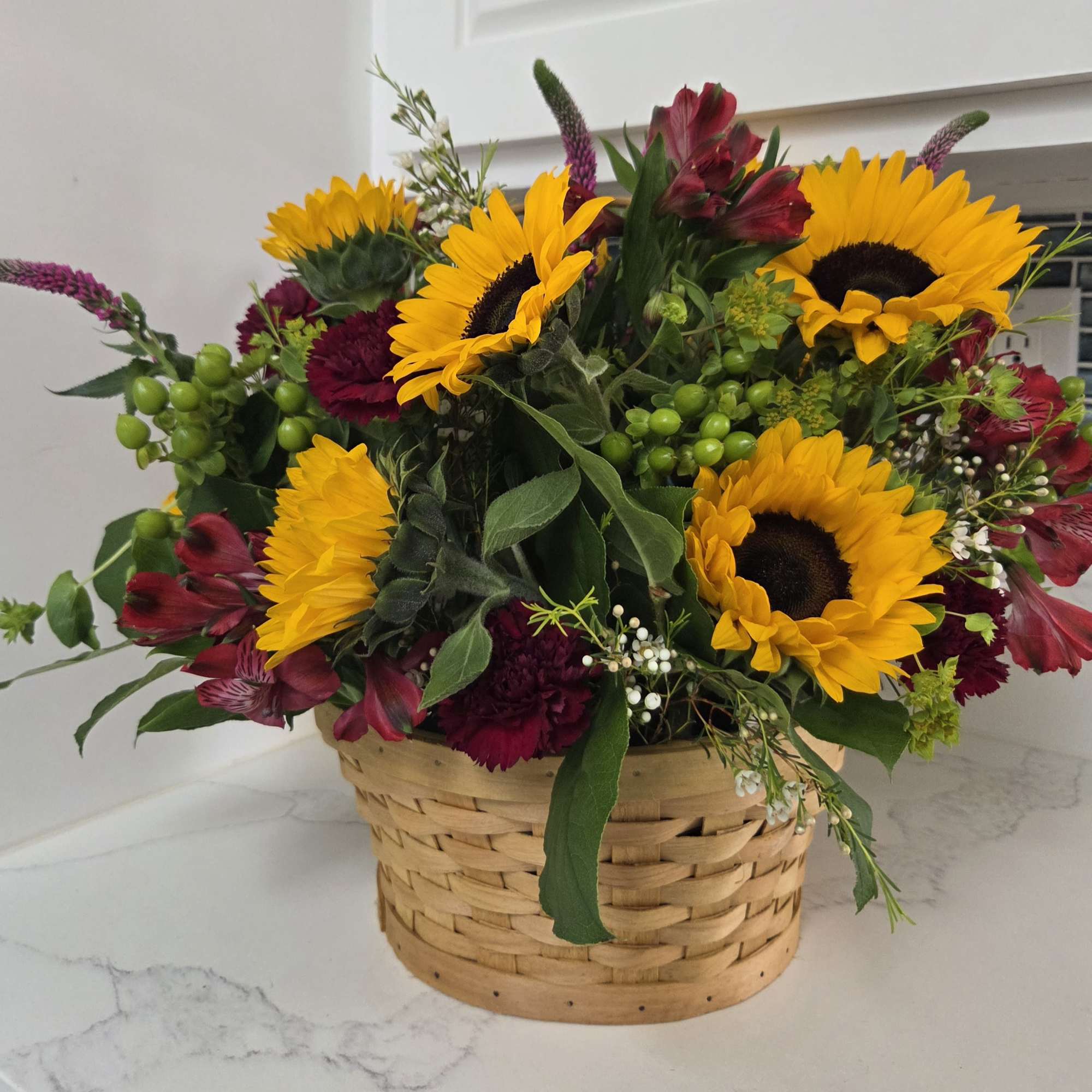 A basket filled with fall sunflowers and flowers in shades of yellow, photo 3 of 3