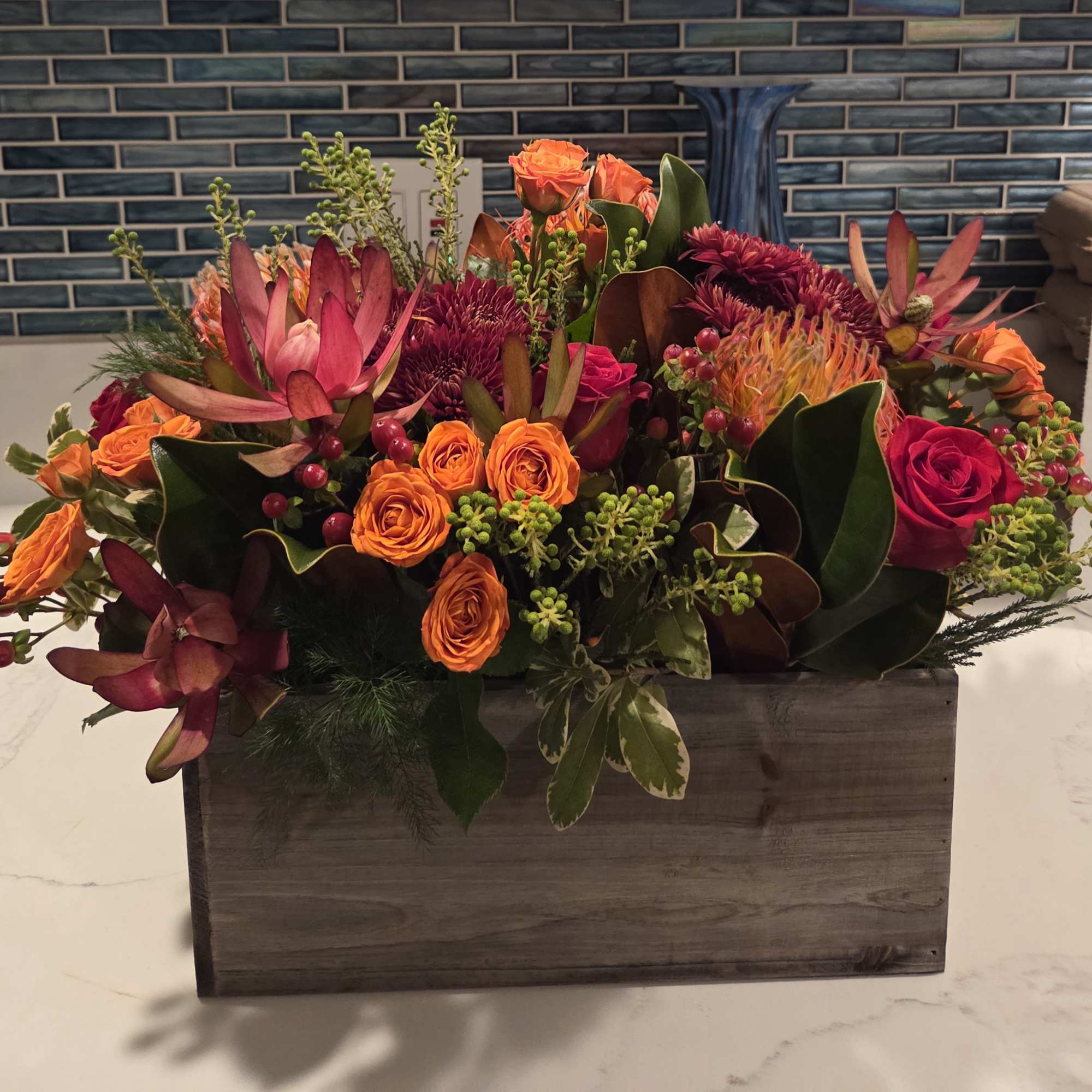 Mixed bouquet of orange and pink flowers in a wooden box