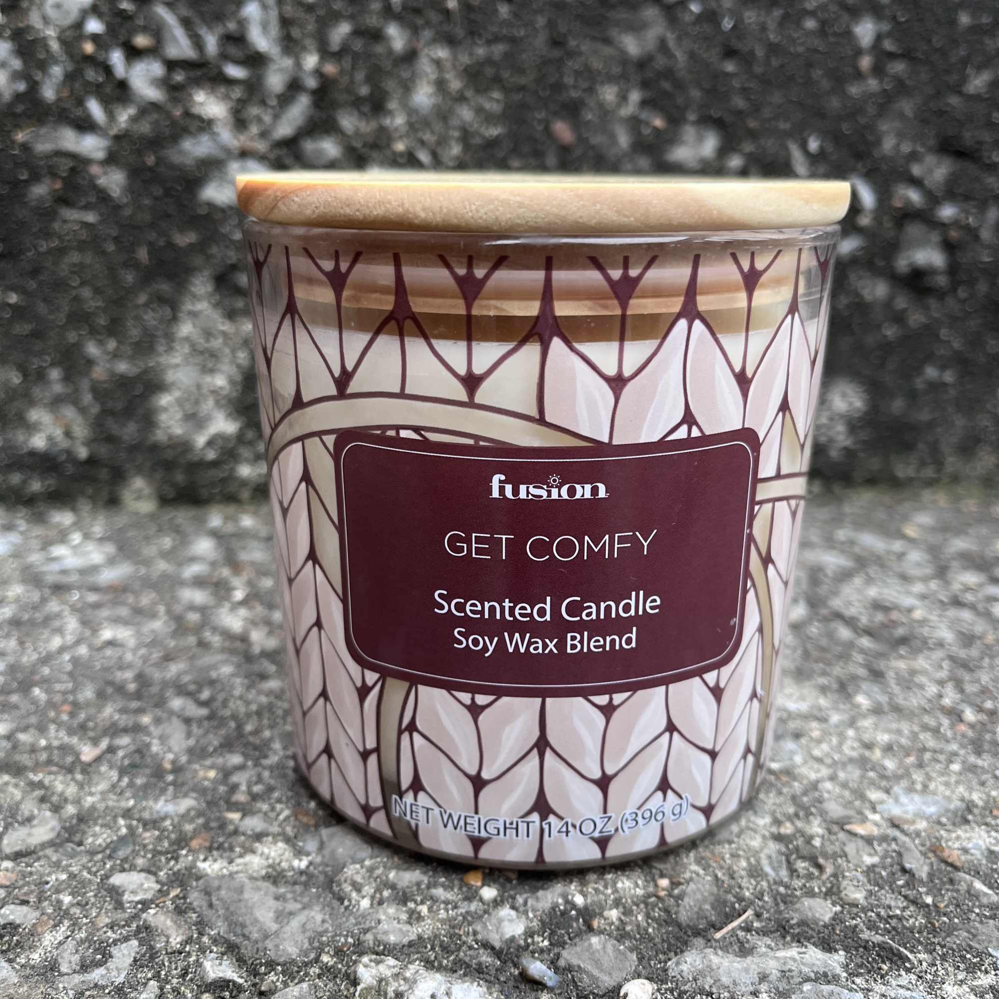 Scented candle in a patterned glass jar with a wooden lid