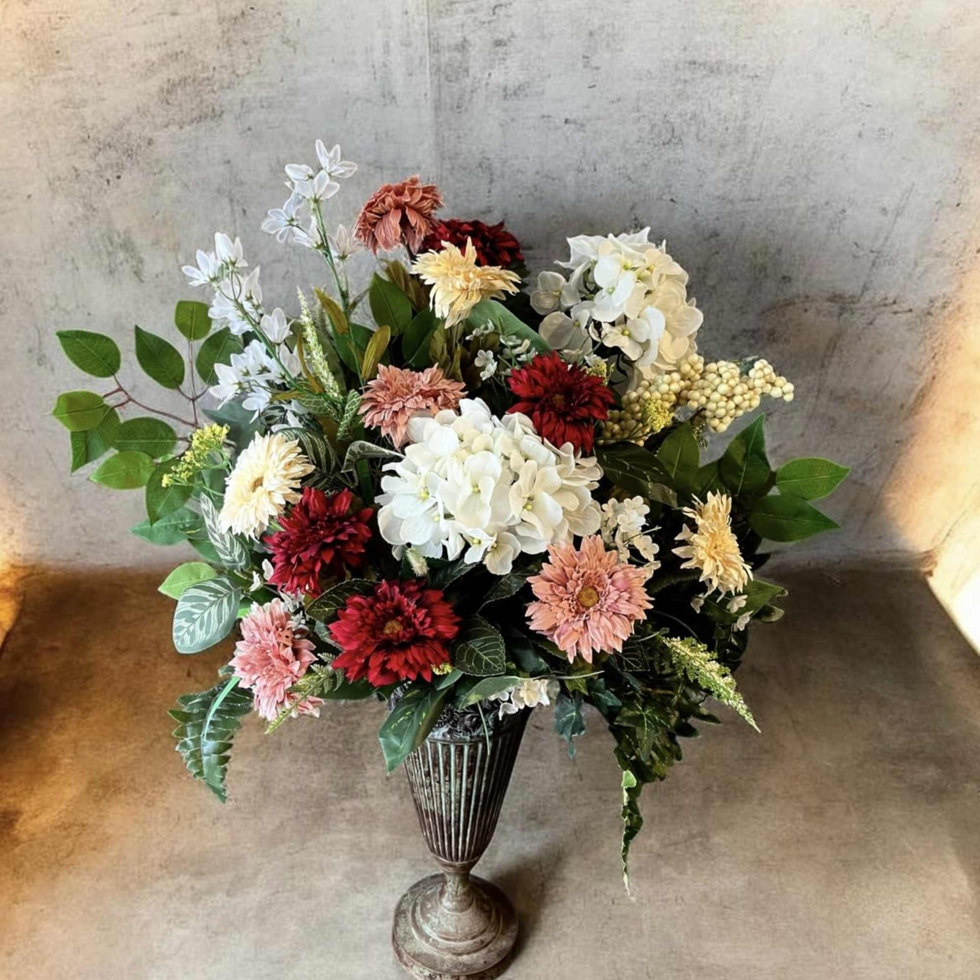 A lush cluster of white hydrangea-like blooms punctuated by deep red and