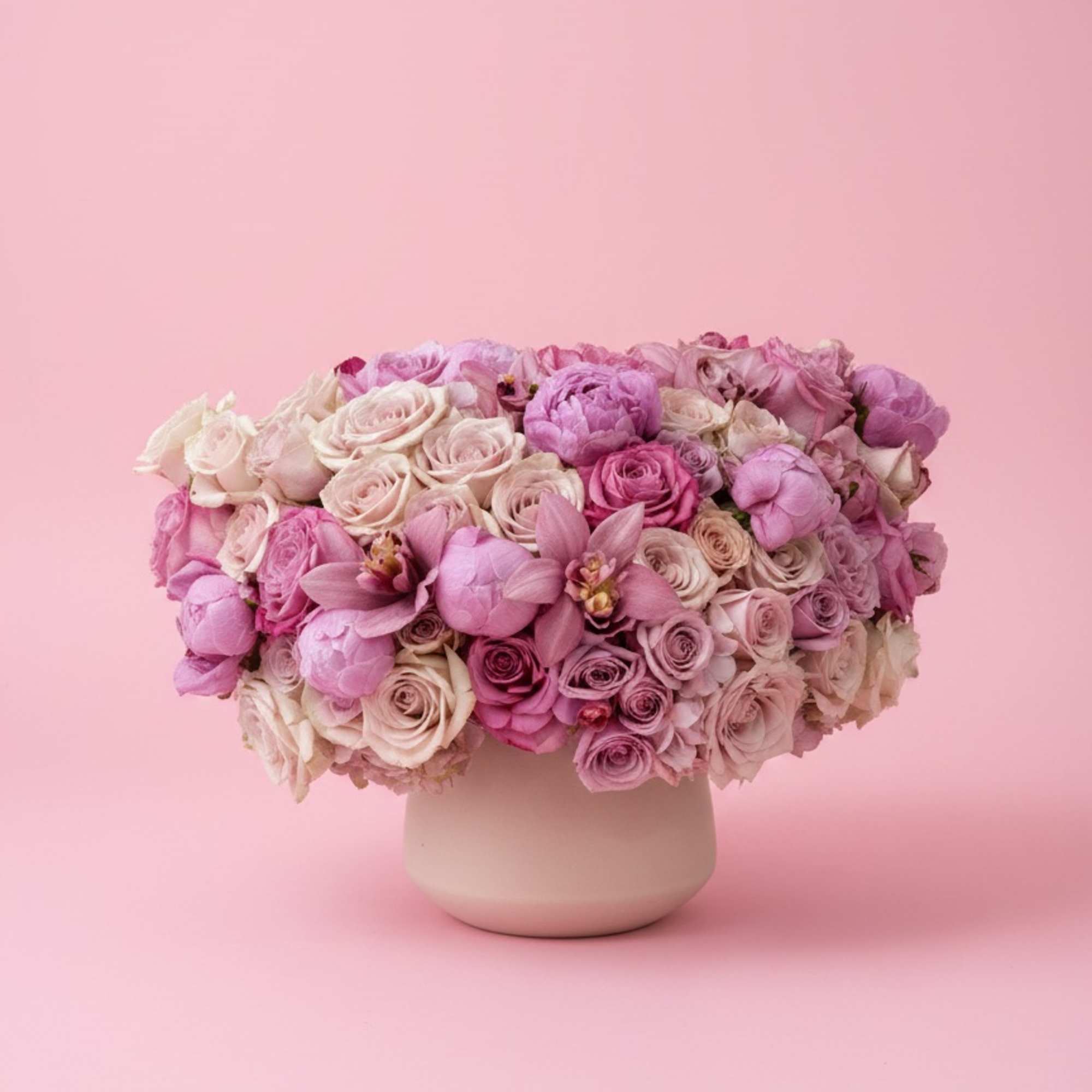 Pink and lavender rose bouquet in a round vase