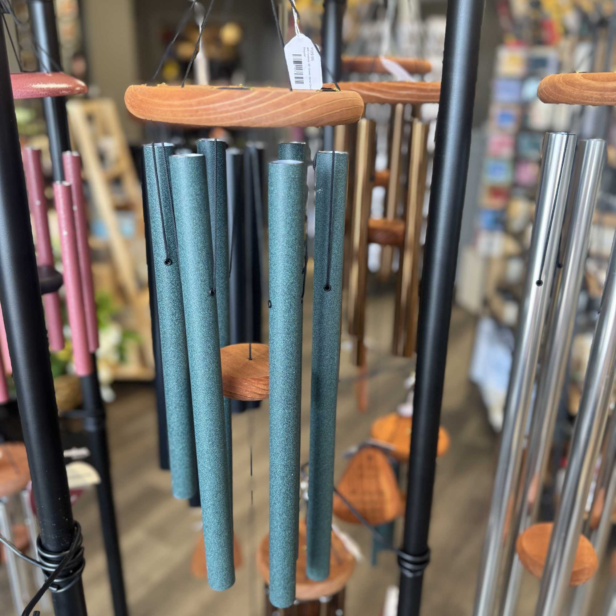 Hanging metal wind chimes with teal tubes and wooden tops