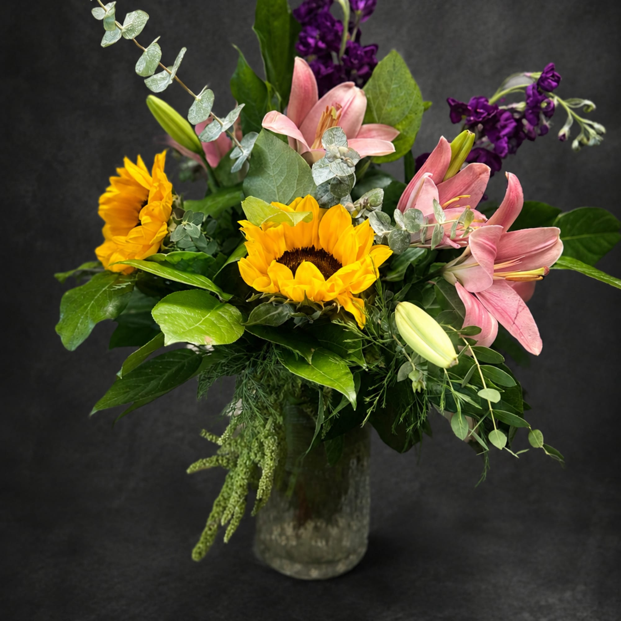 Bright yellow sunflowers and soft pink lilies create an immediate, sunny welcome
