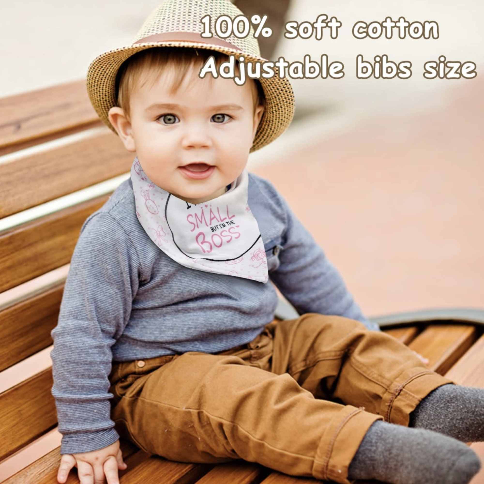 Baby wearing a hat and bib sitting on a bench