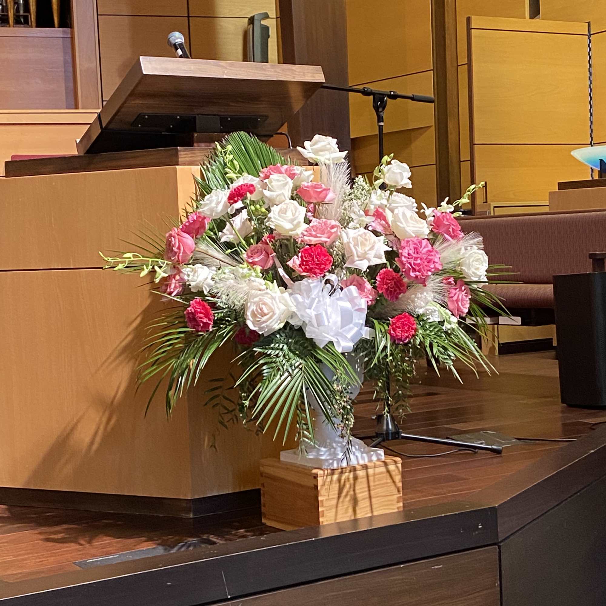 Pink and white floral arrangement on a stage podium