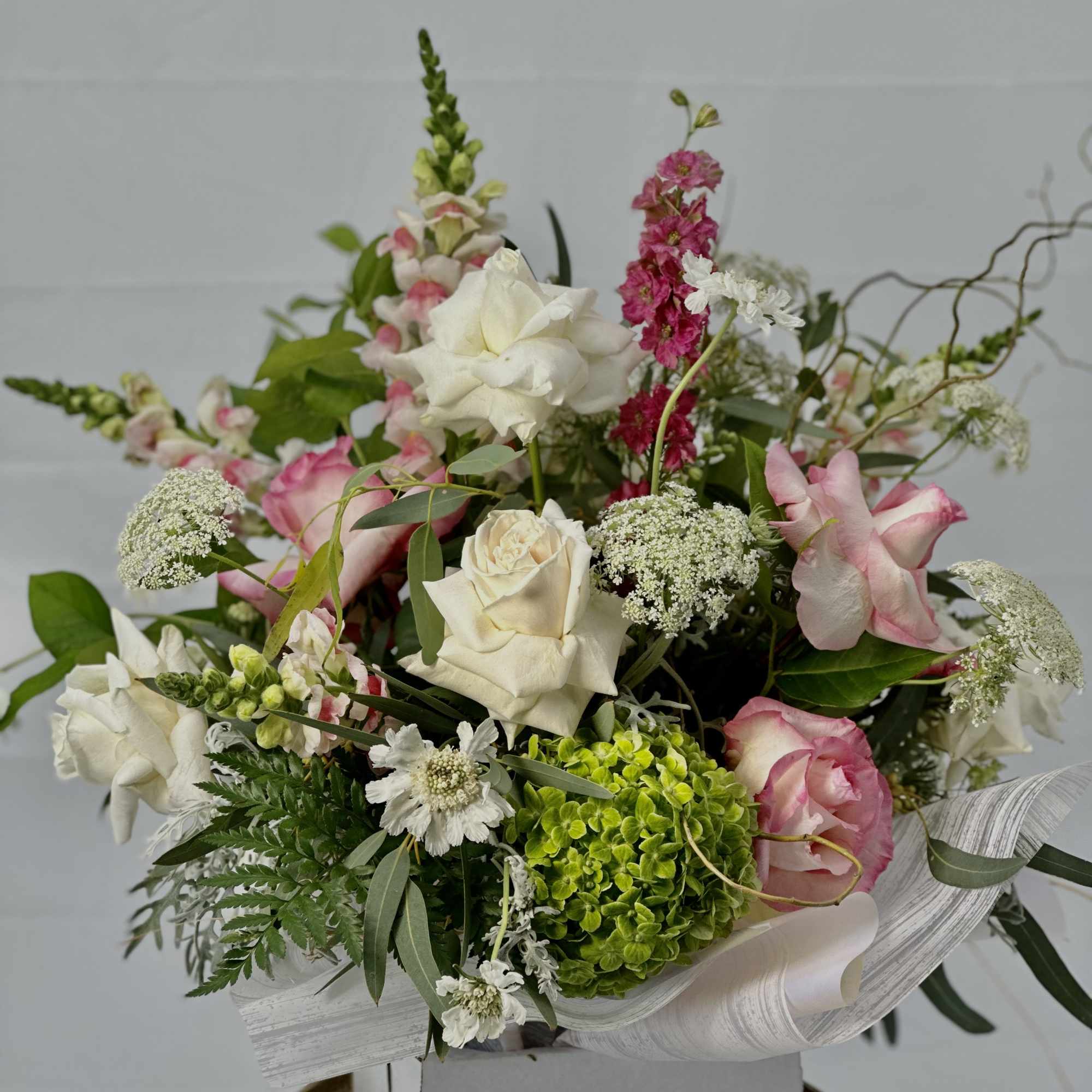 Bouquet of white and pink roses with mixed blooms in a box
