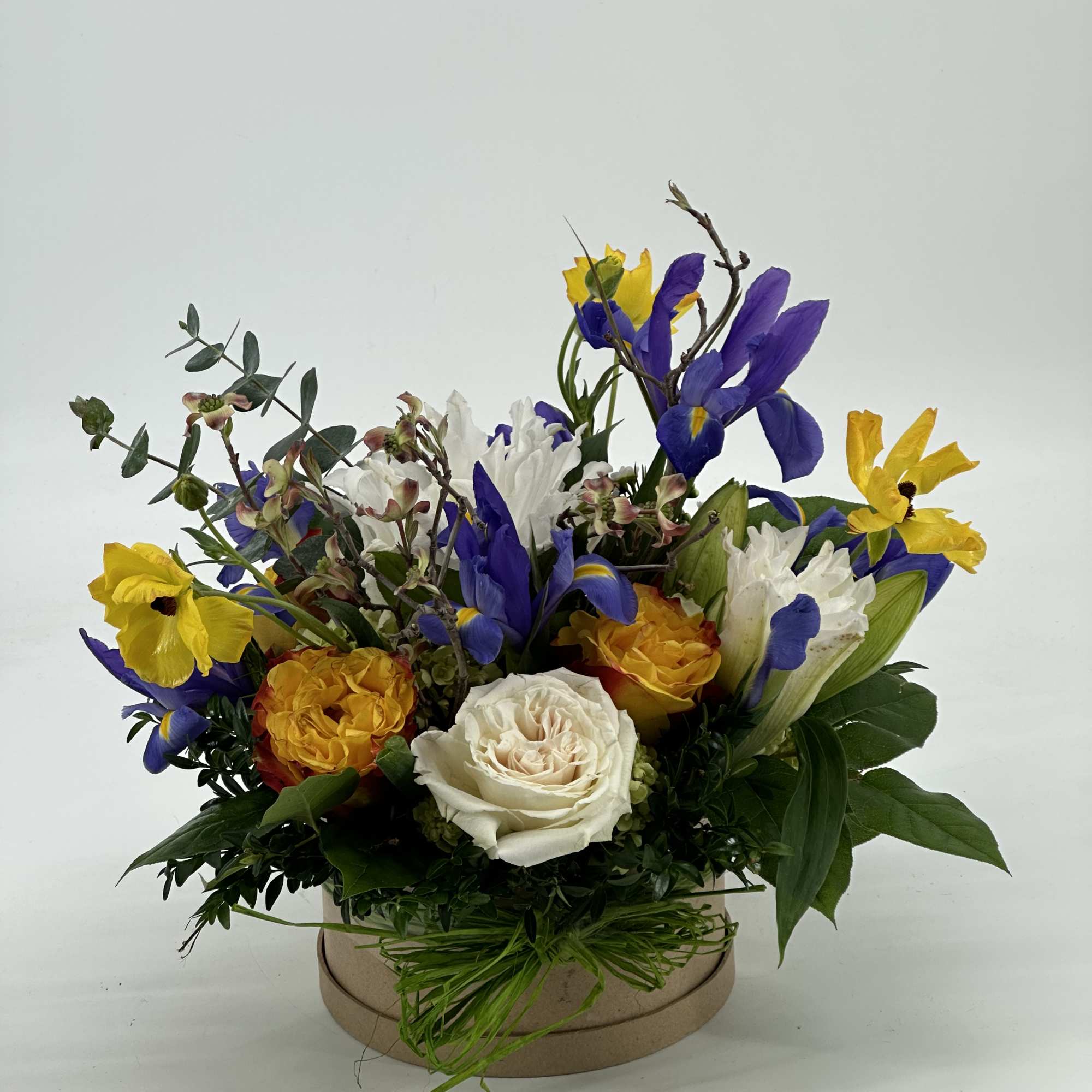 Colorful mixed flower arrangement in a round box
