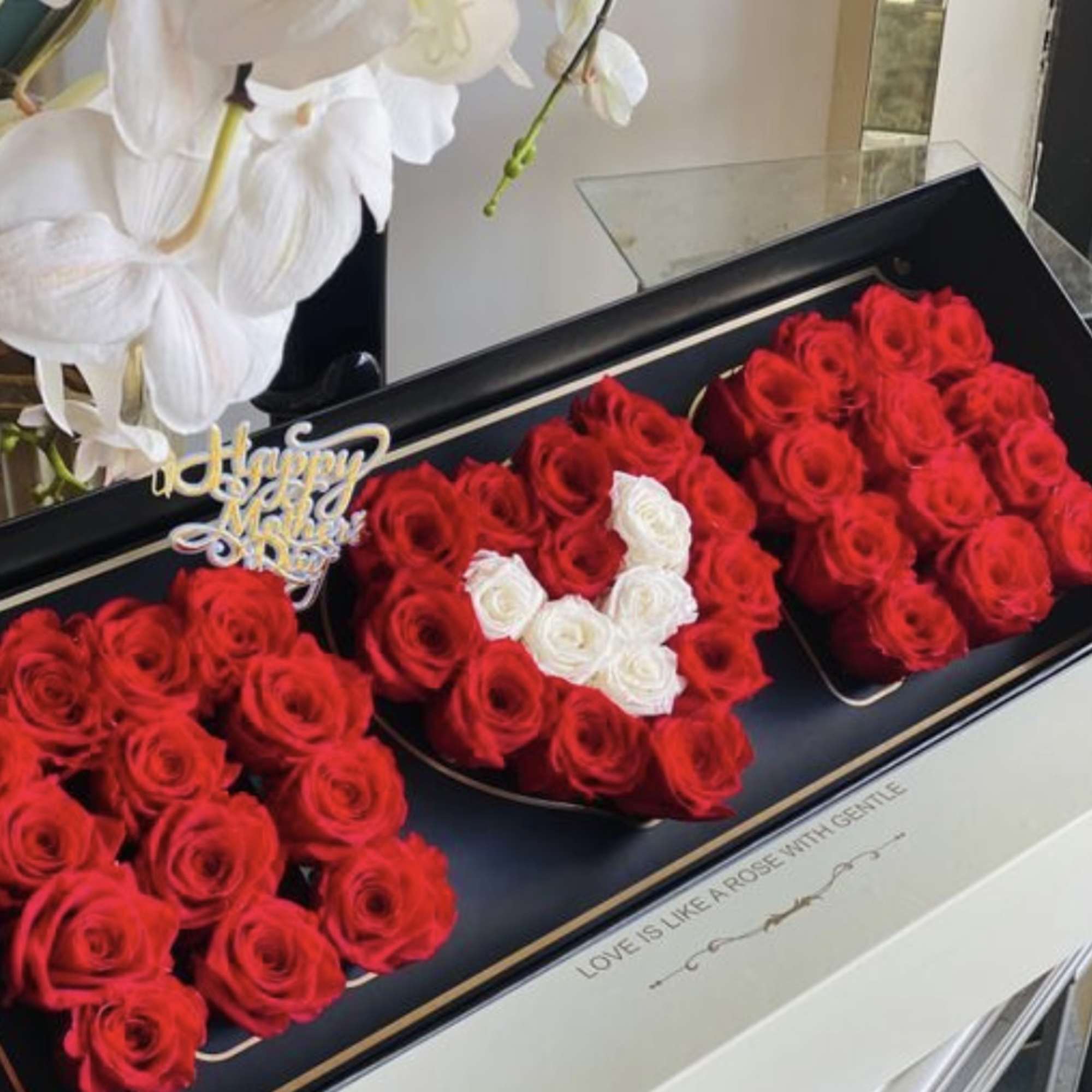 Three heart-shaped boxes filled with red roses and white roses