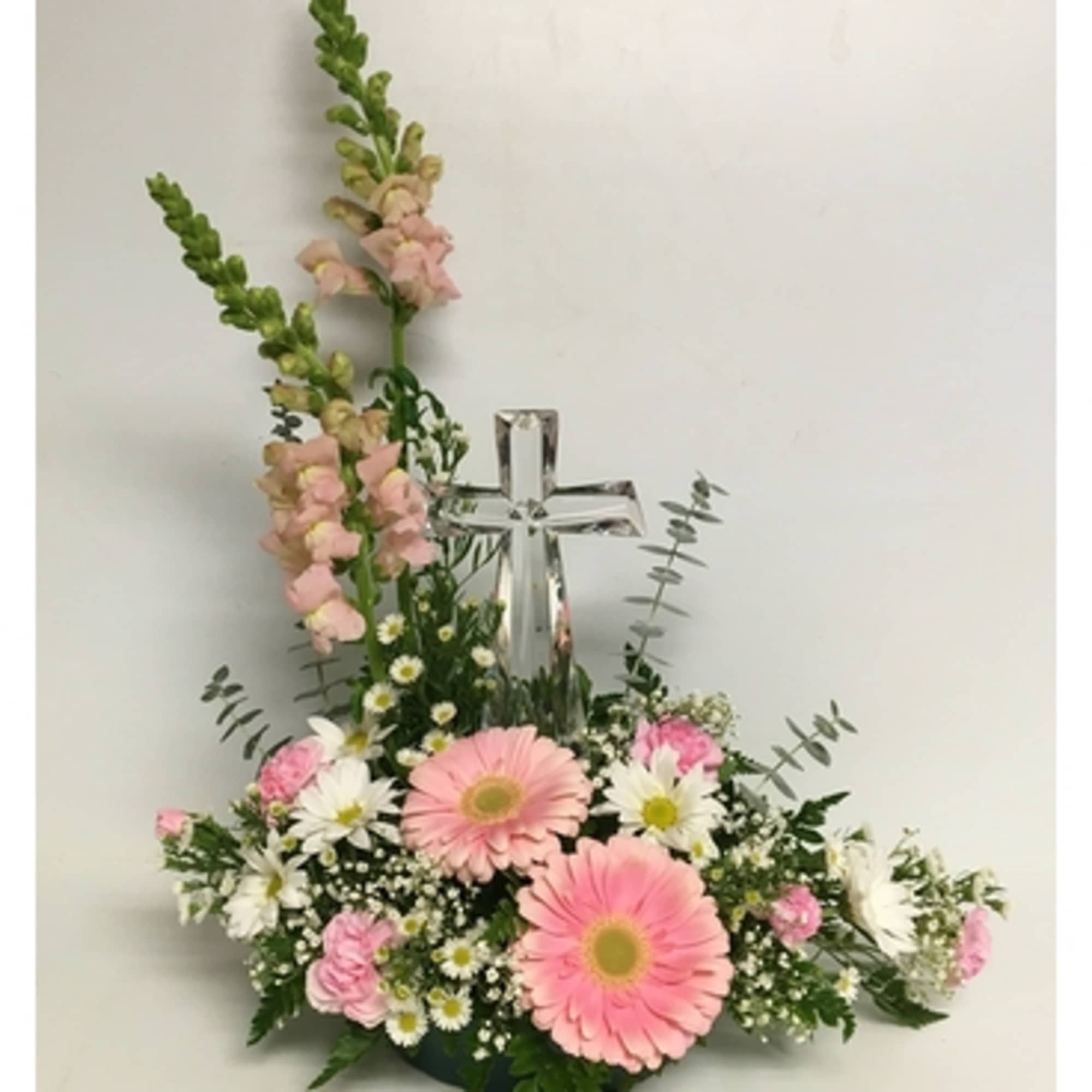 Pink and white floral arrangement with a clear cross centerpiece