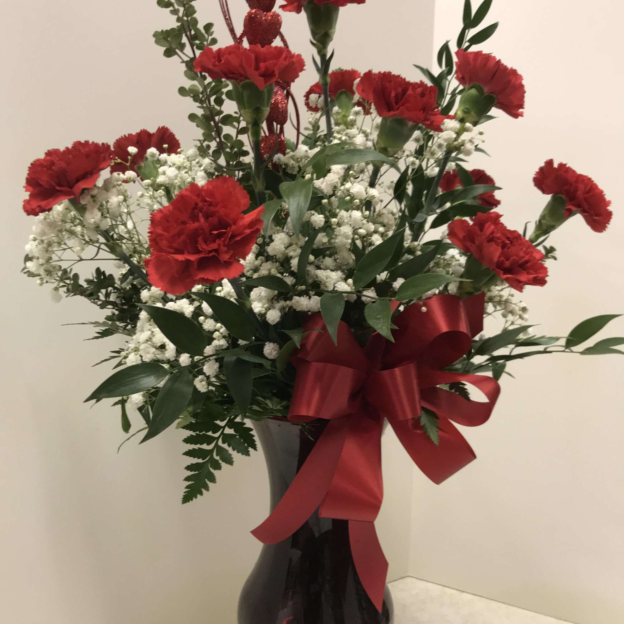 A fresh arrangement in a ruby container and filled with beautiful fresh