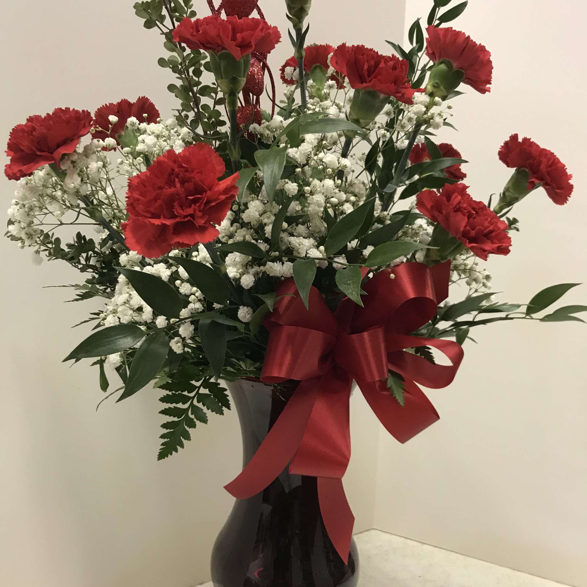 A fresh arrangement in a ruby container and filled with beautiful fresh
