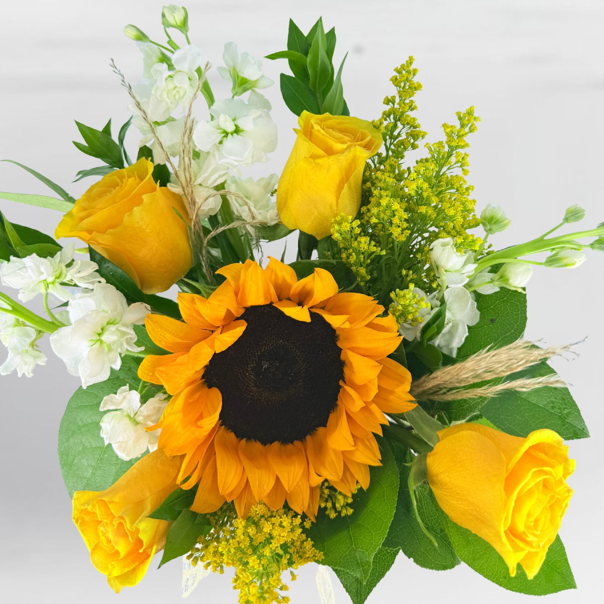 Bouquet with yellow roses, a sunflower, and white flowers