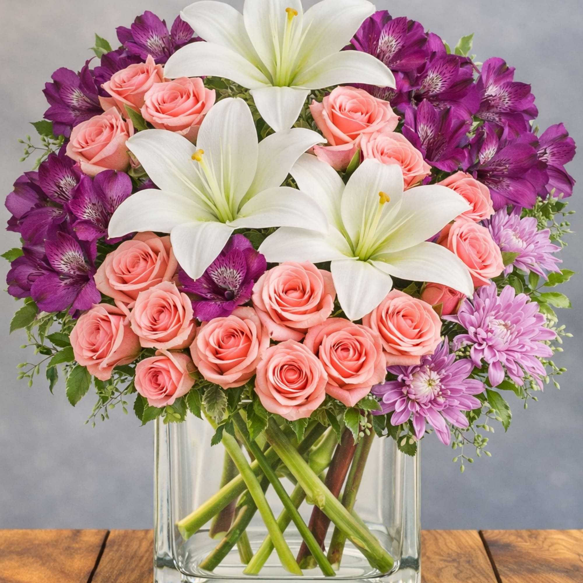 Soft pink roses and large white lilies mingle with vivid purple alstroemeria
