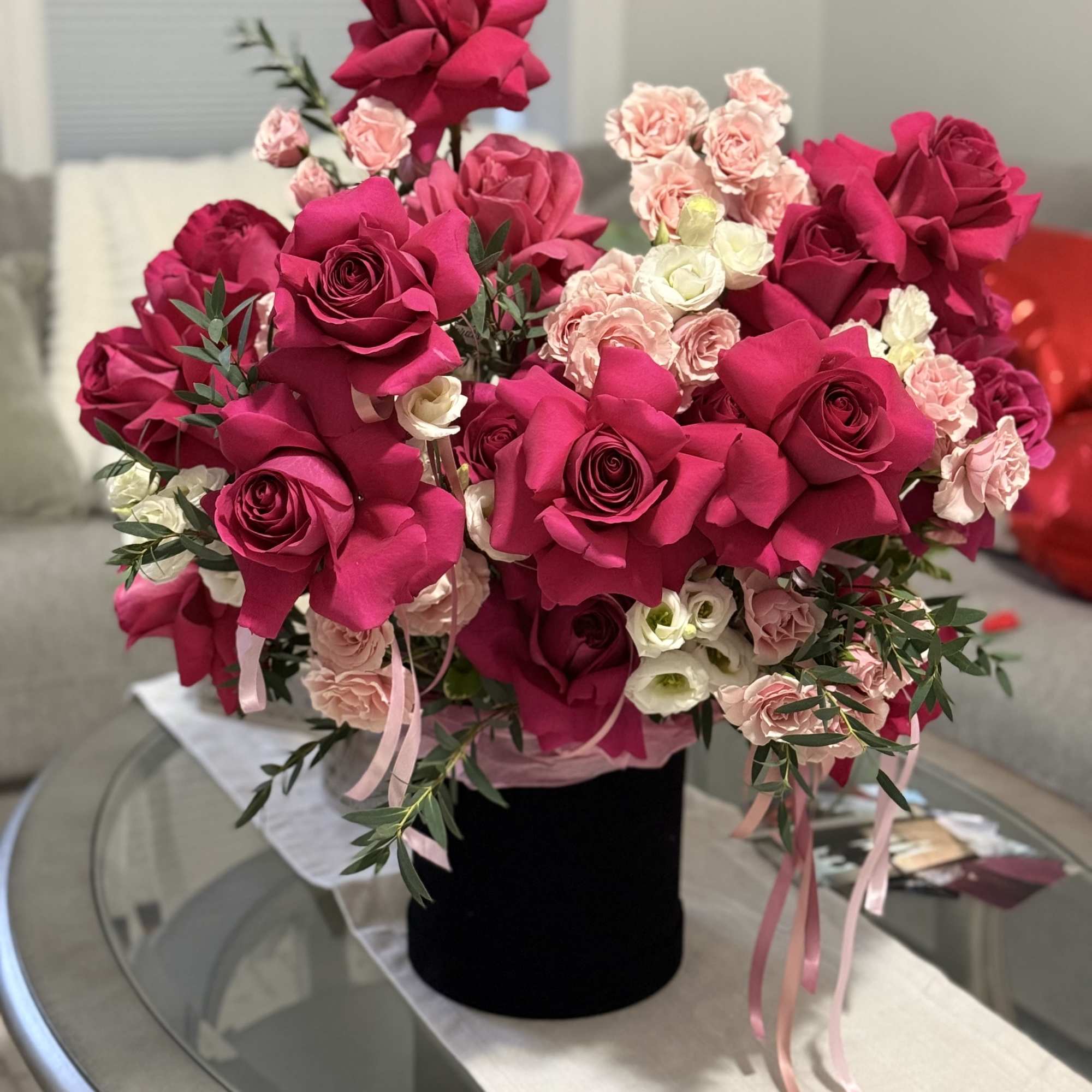 A bold, glam hatbox arrangement packed with hot pink roses, soft blush