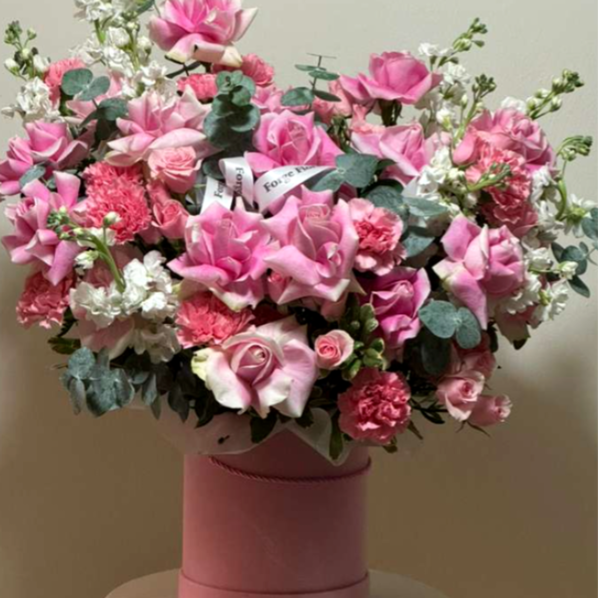 Fragrant eucalyptus with pink French roses in a cute pink hat box!