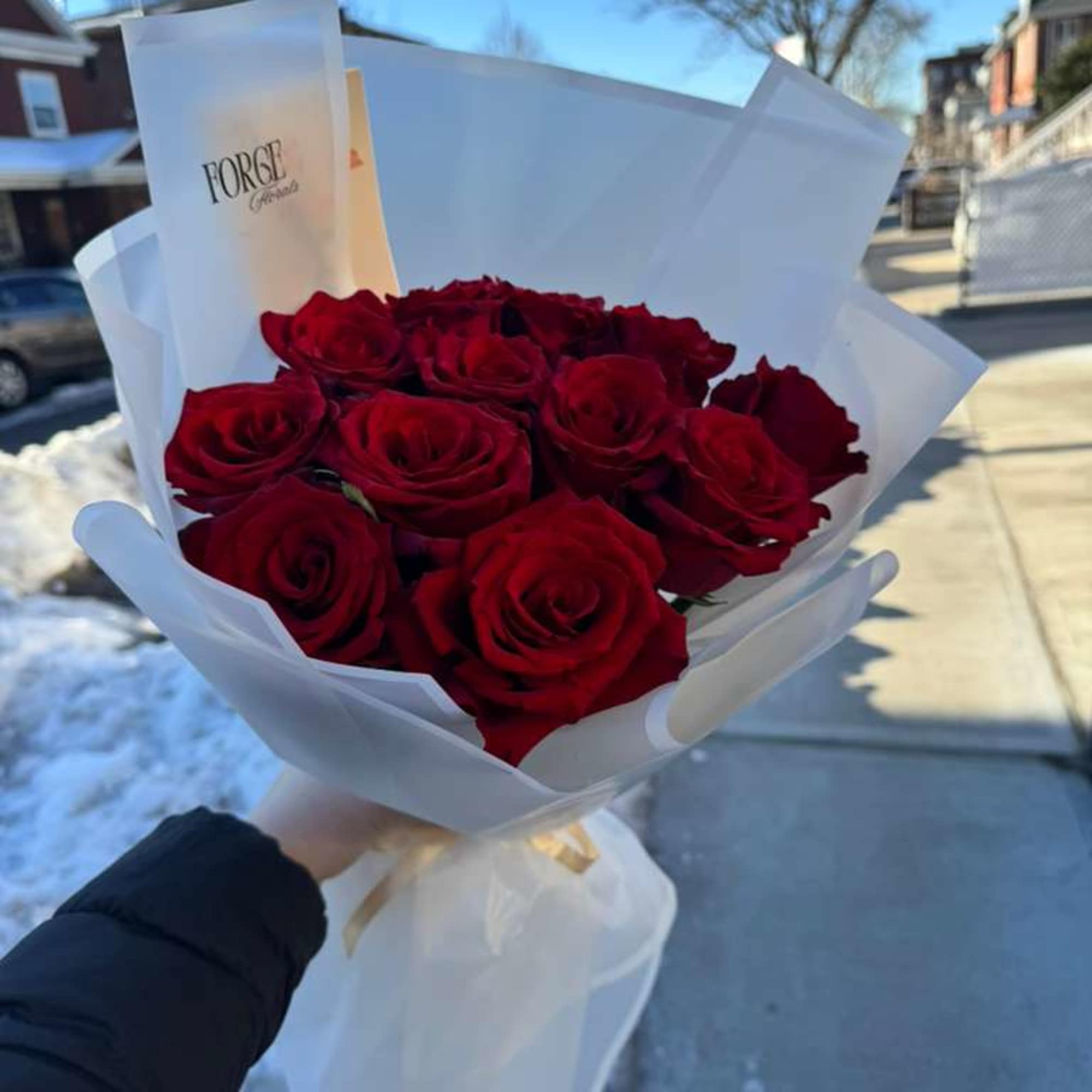 A timeless bouquet of 12 velvety red roses, wrapped in soft blush