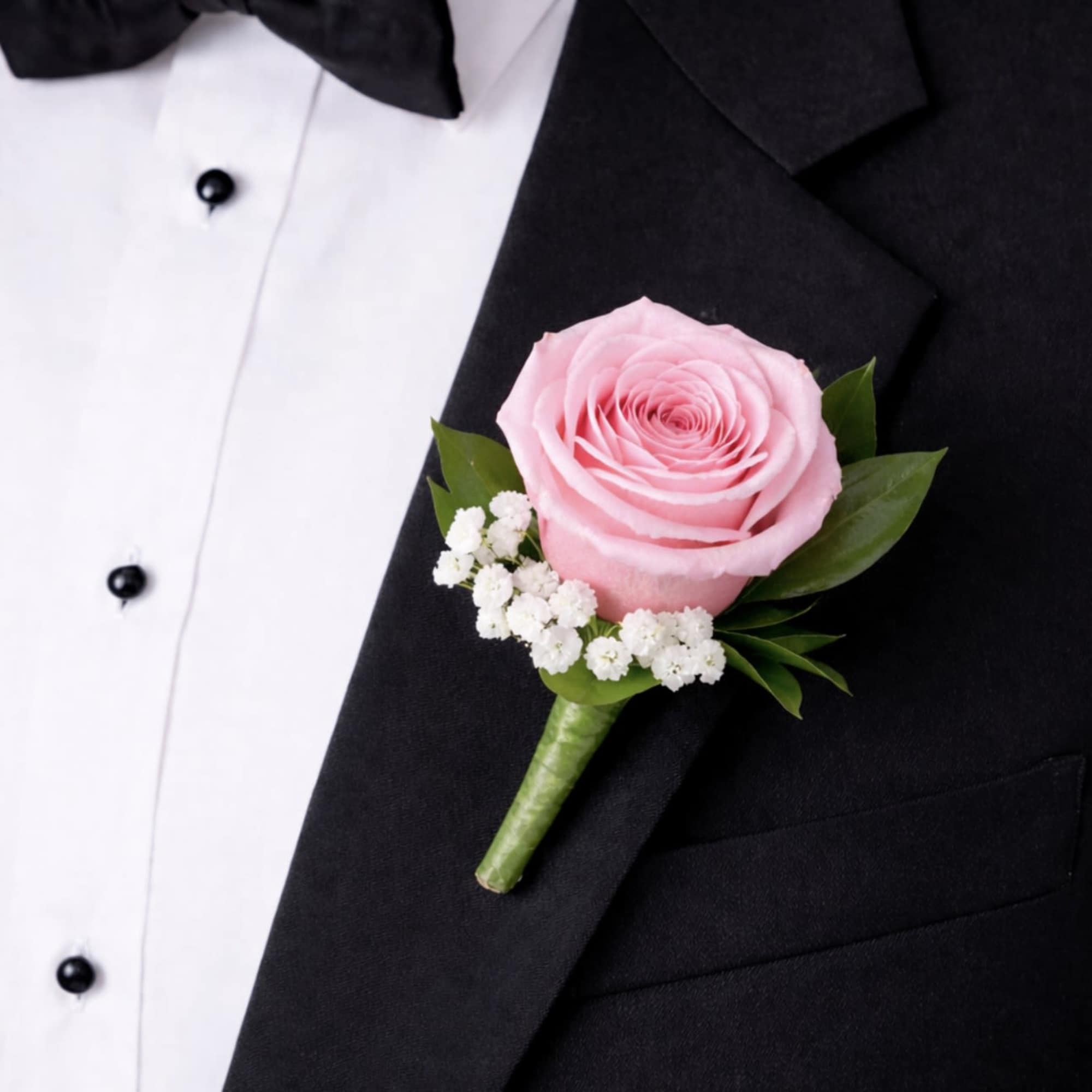 This light pink rose boutonniere is a timeless lapel accessory featuring a