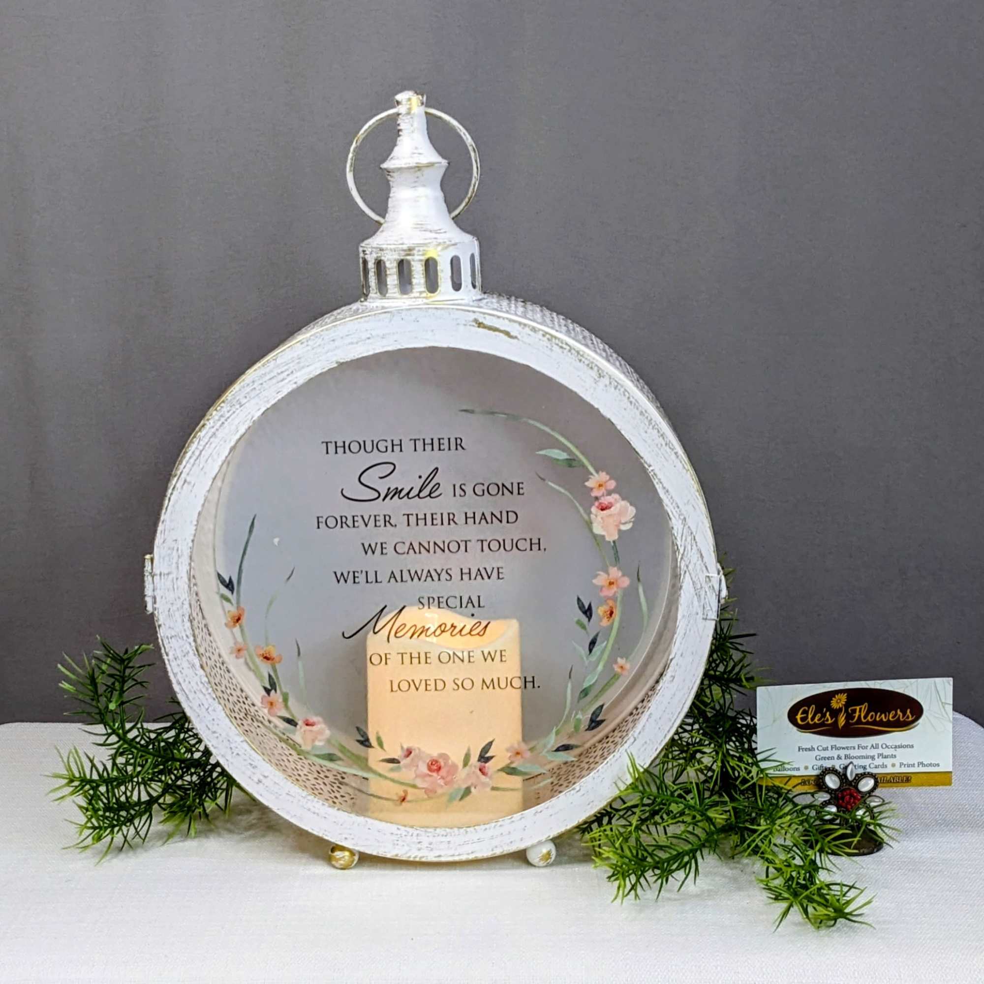 White memorial lantern with floral accents and a sympathy message