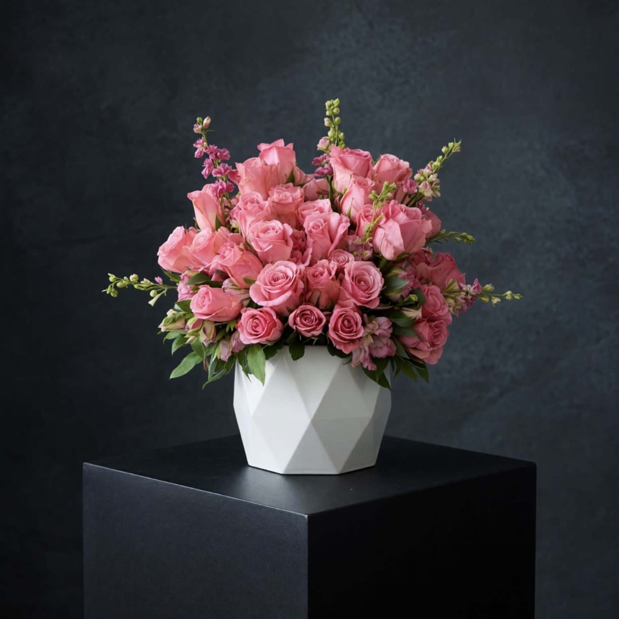 Pink rose bouquet in a white geometric vase