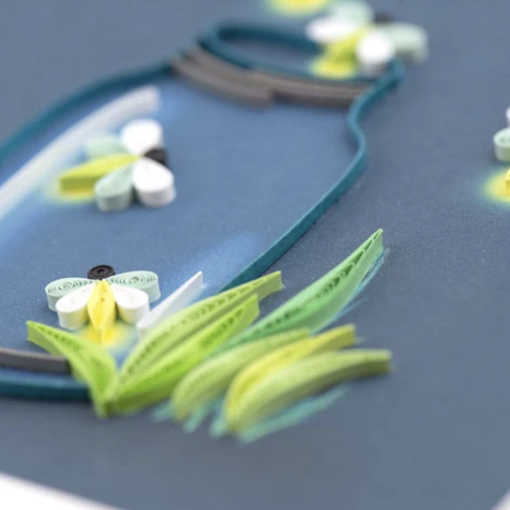 Paper quilled floral design on a blue background