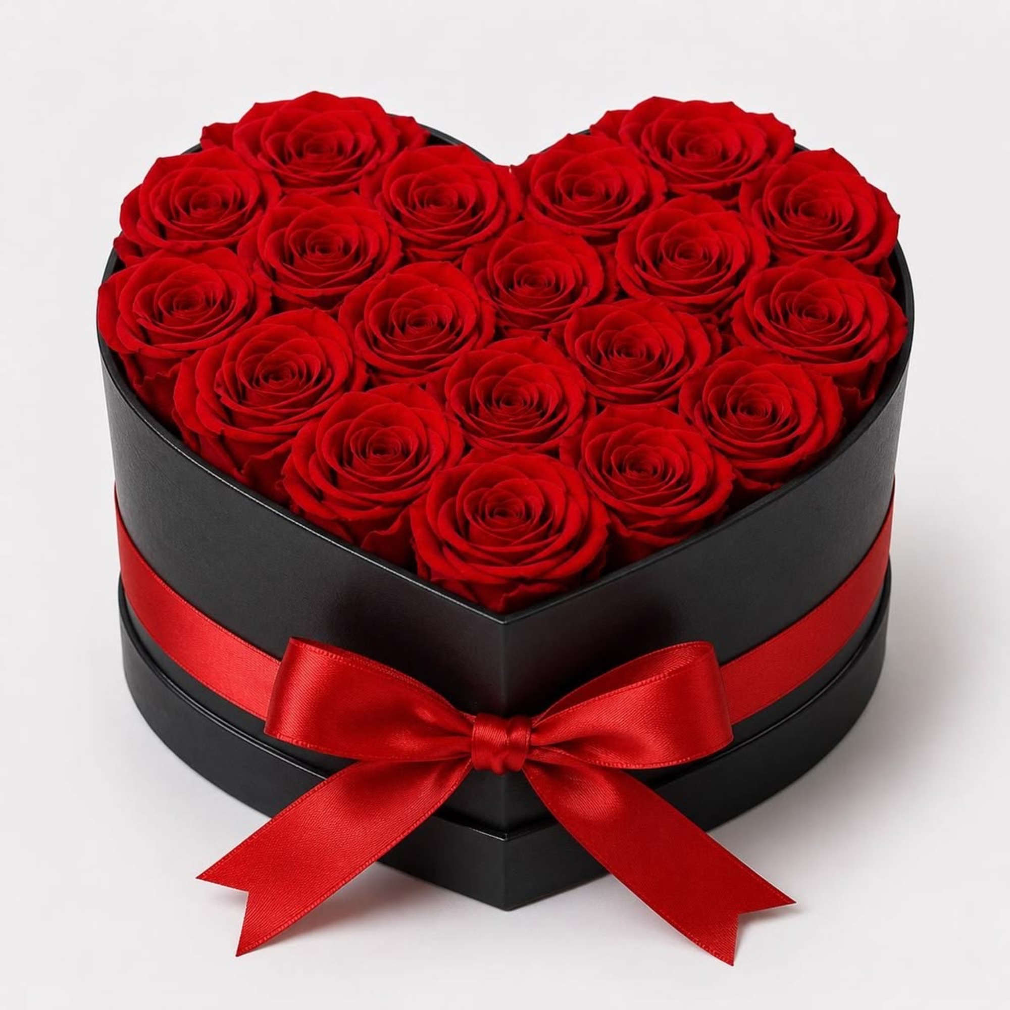 Heart-shaped box filled with red roses and tied with a red ribbon