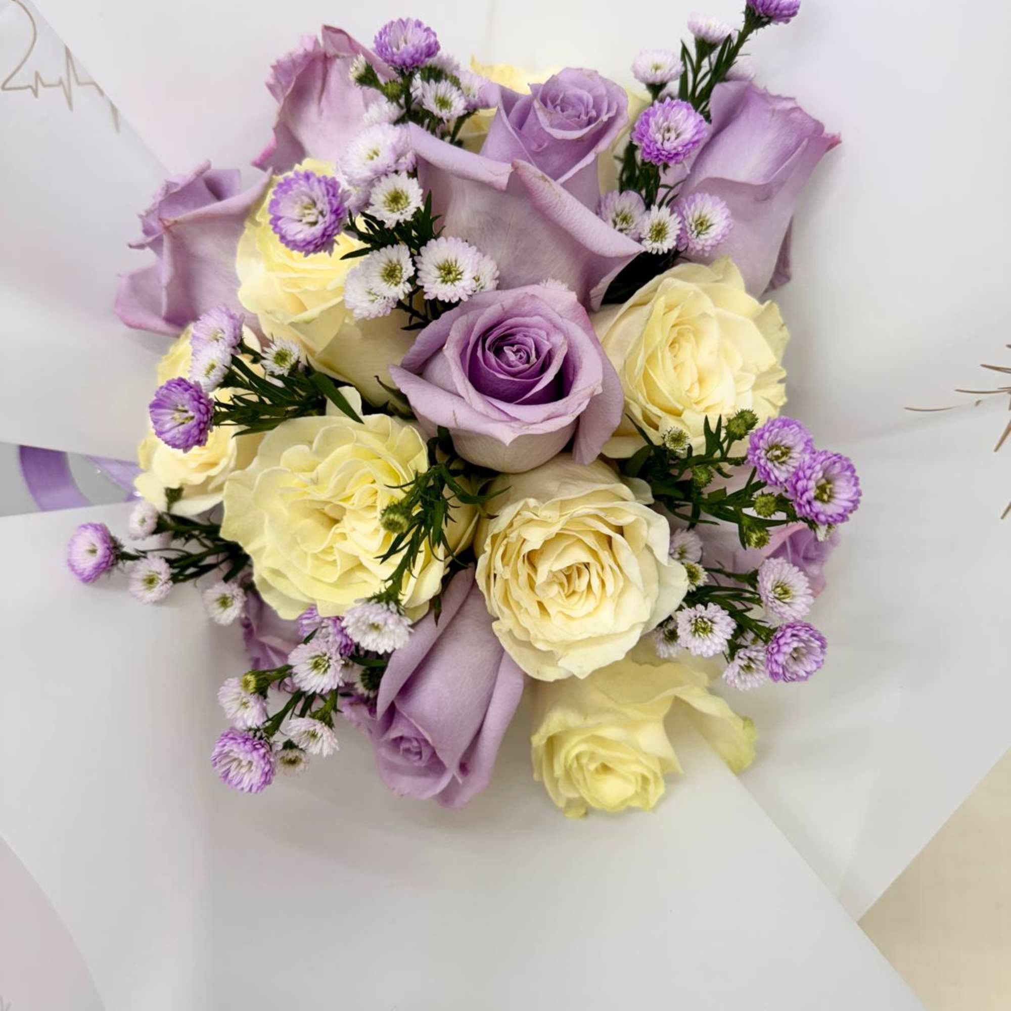 Bouquet of lavender and cream roses with small purple filler flowers