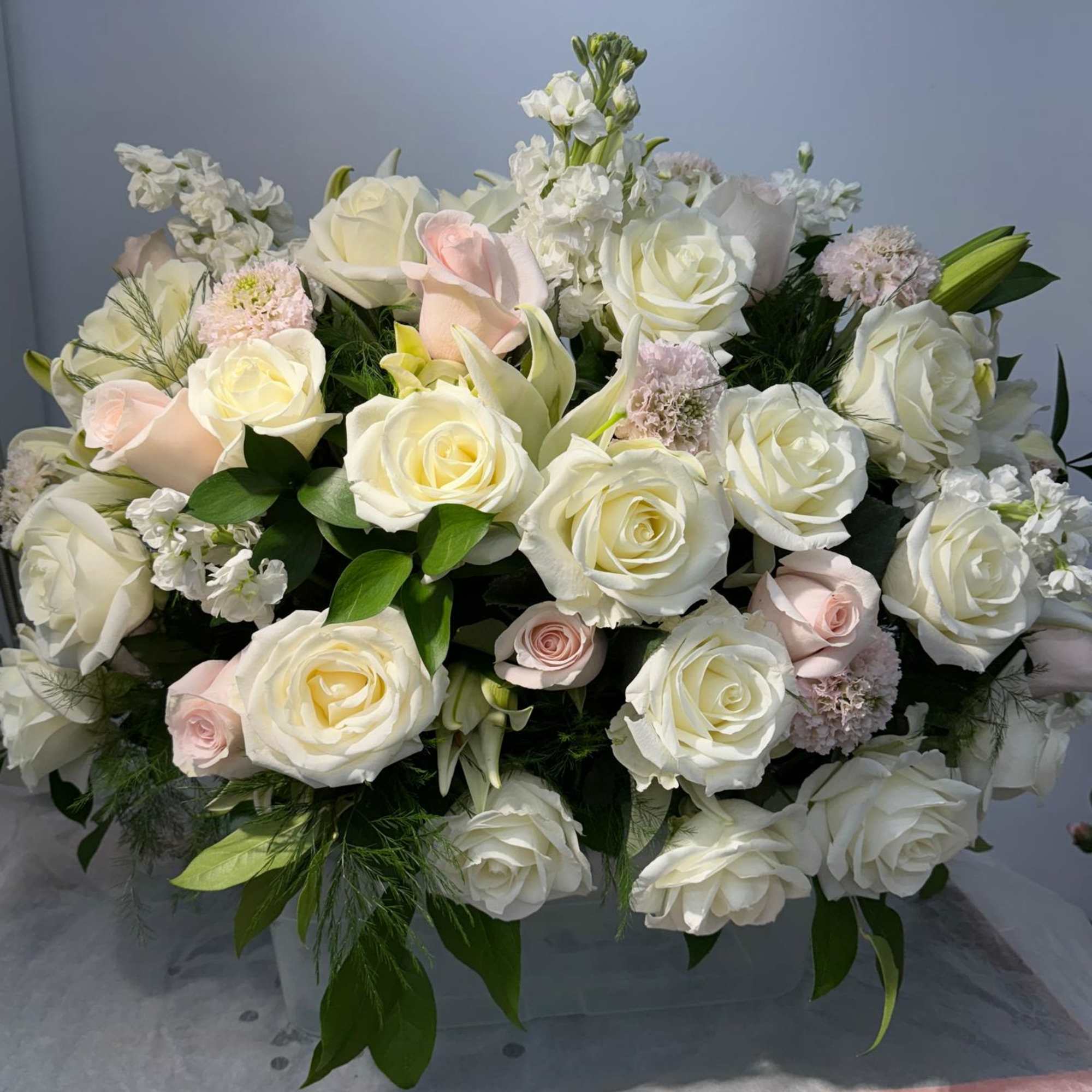 Large bouquet of white and blush roses with white filler flowers