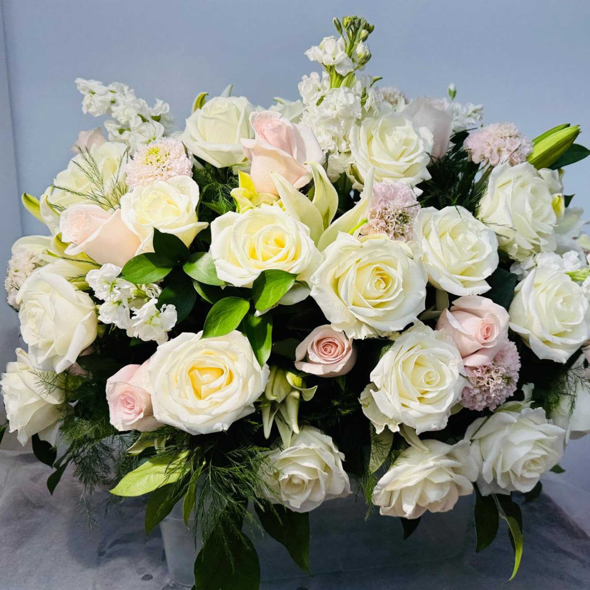 Large bouquet of white and blush roses with white filler flowers