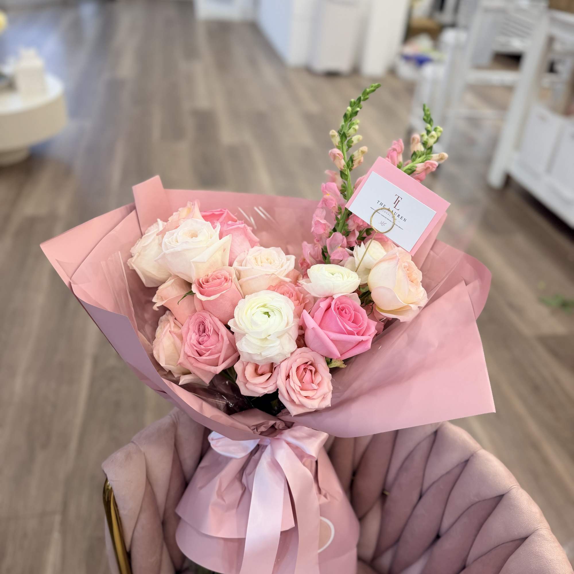 A lush, hand-tied bouquet in soft pinks, peach, cream and a touch