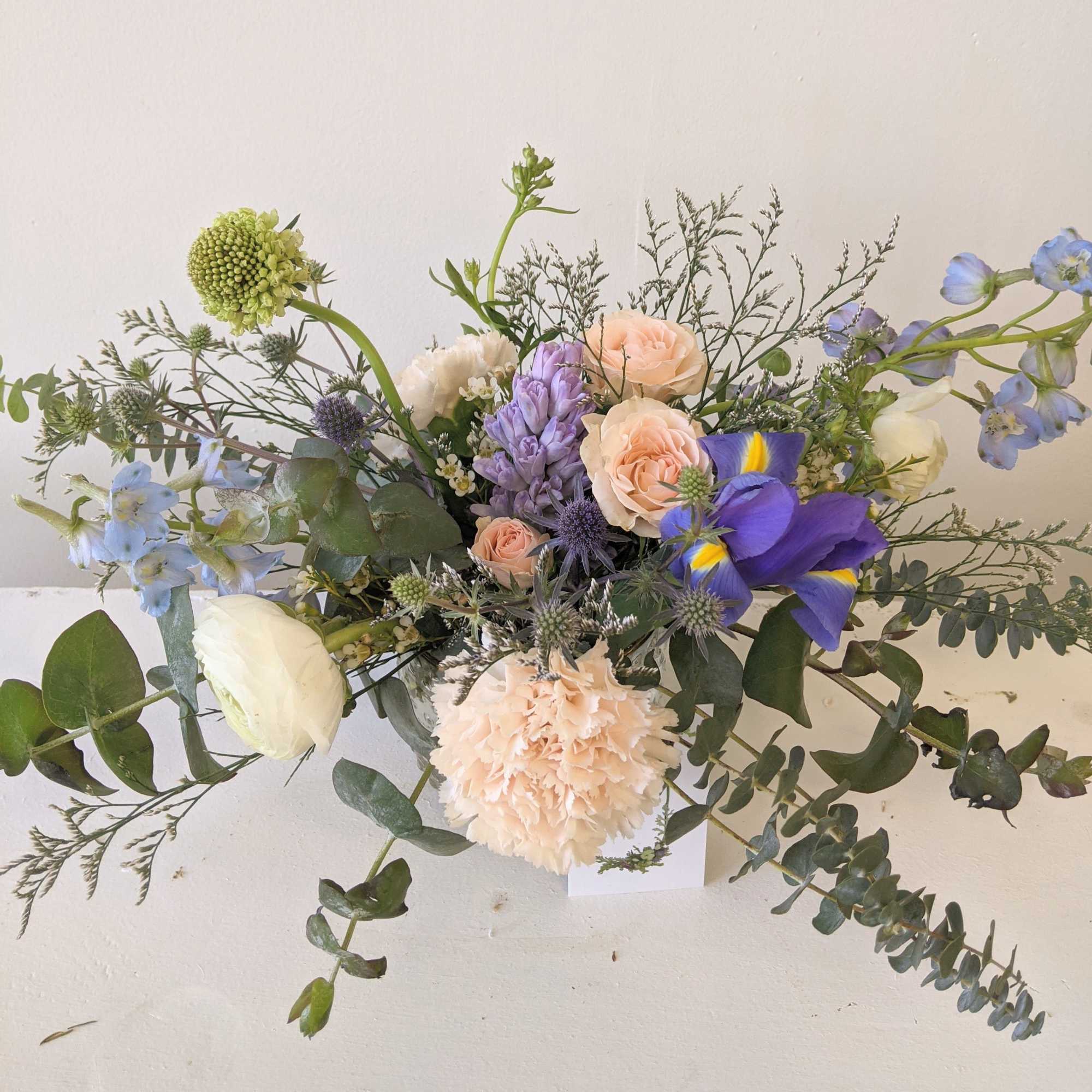 A small arrangement in a hobnail glass jar with pastel tones. 