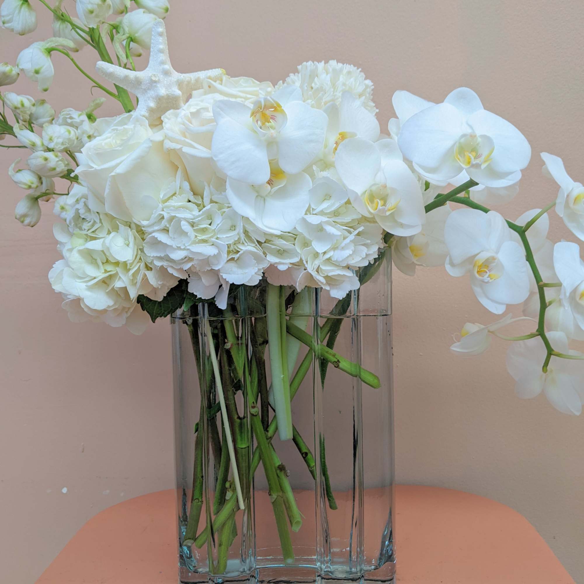 White flowers arranged in a clear rectangular vase