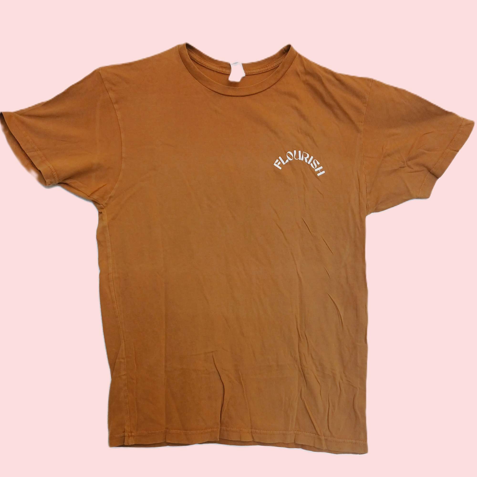 Brown T-shirt with small white text on a pink background