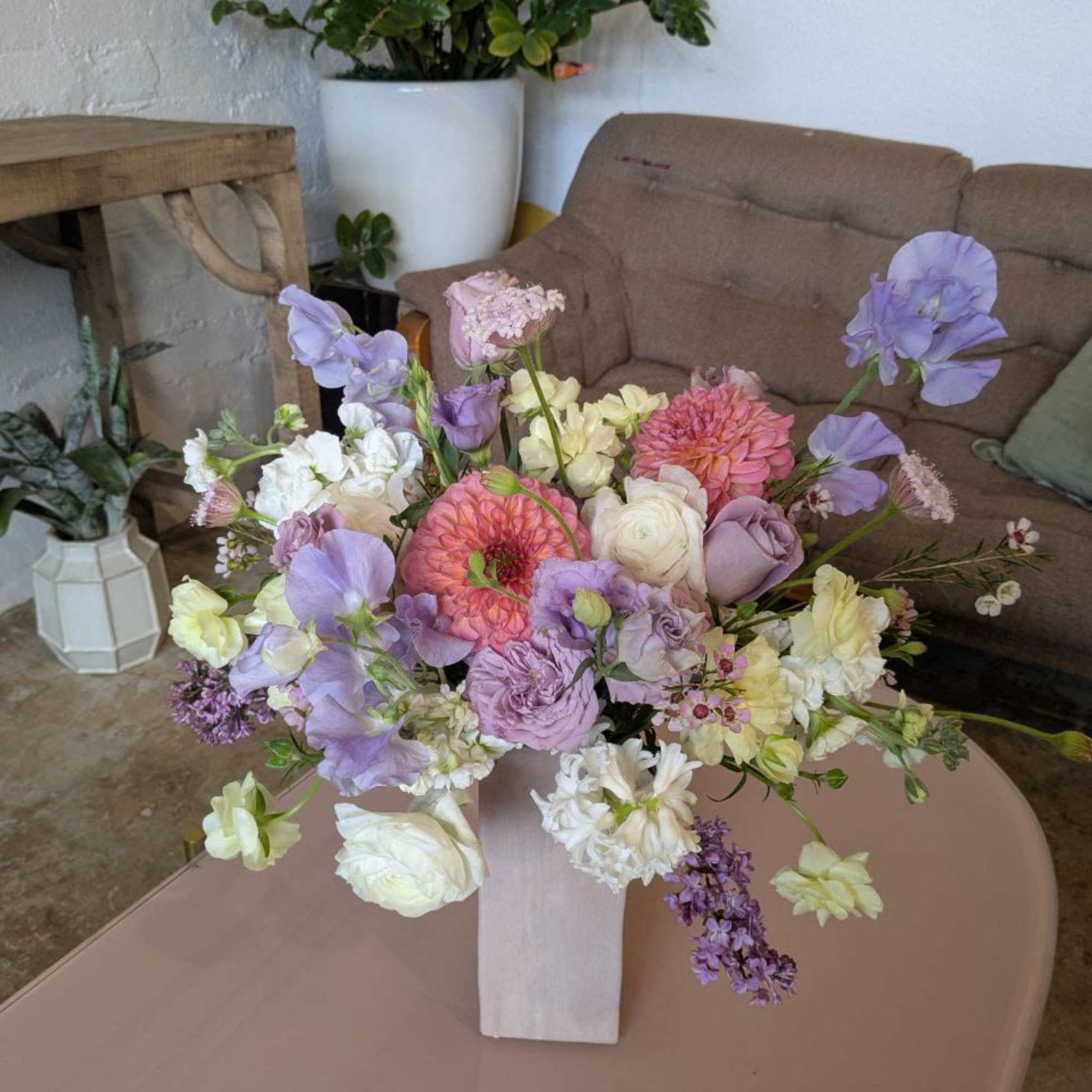 Pastel flower arrangement in a white vase on a table