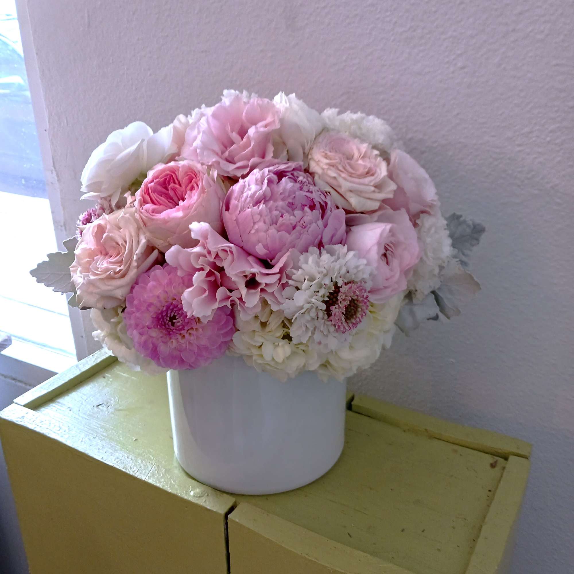Pink and white flower arrangement in a white vase