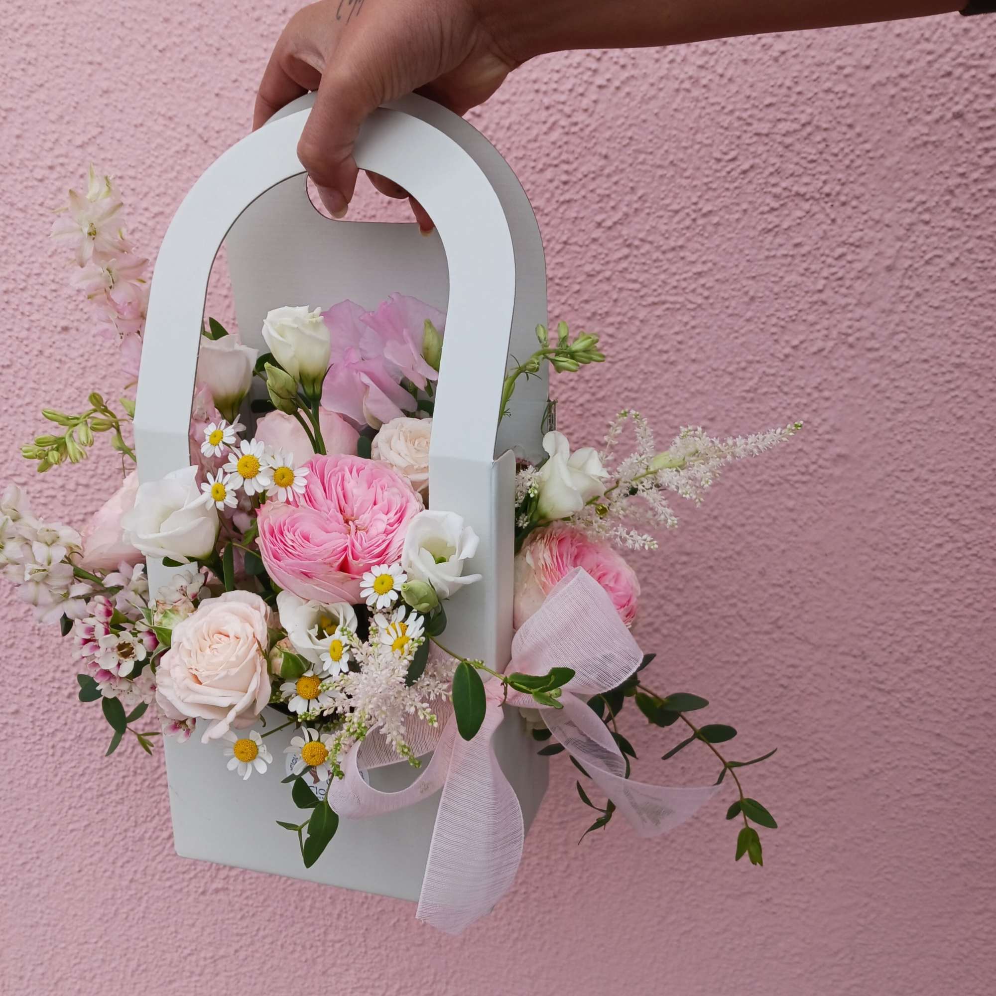 Pink and white flower arrangement in a white handbag-shaped box