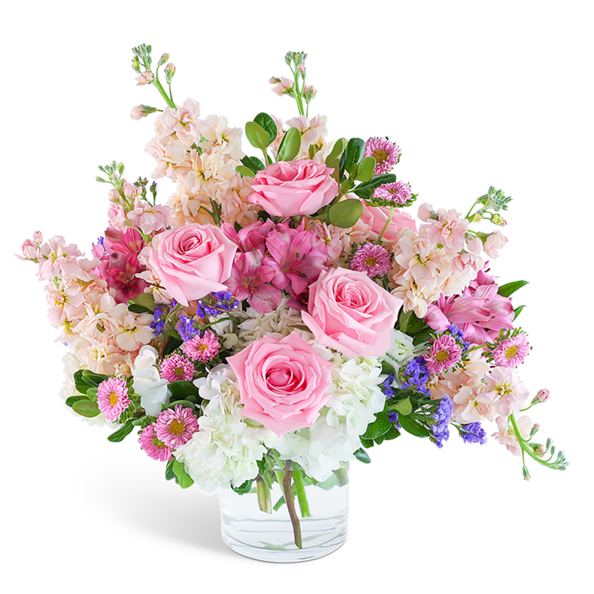 Pink roses and mixed blooms arranged in a clear glass vase