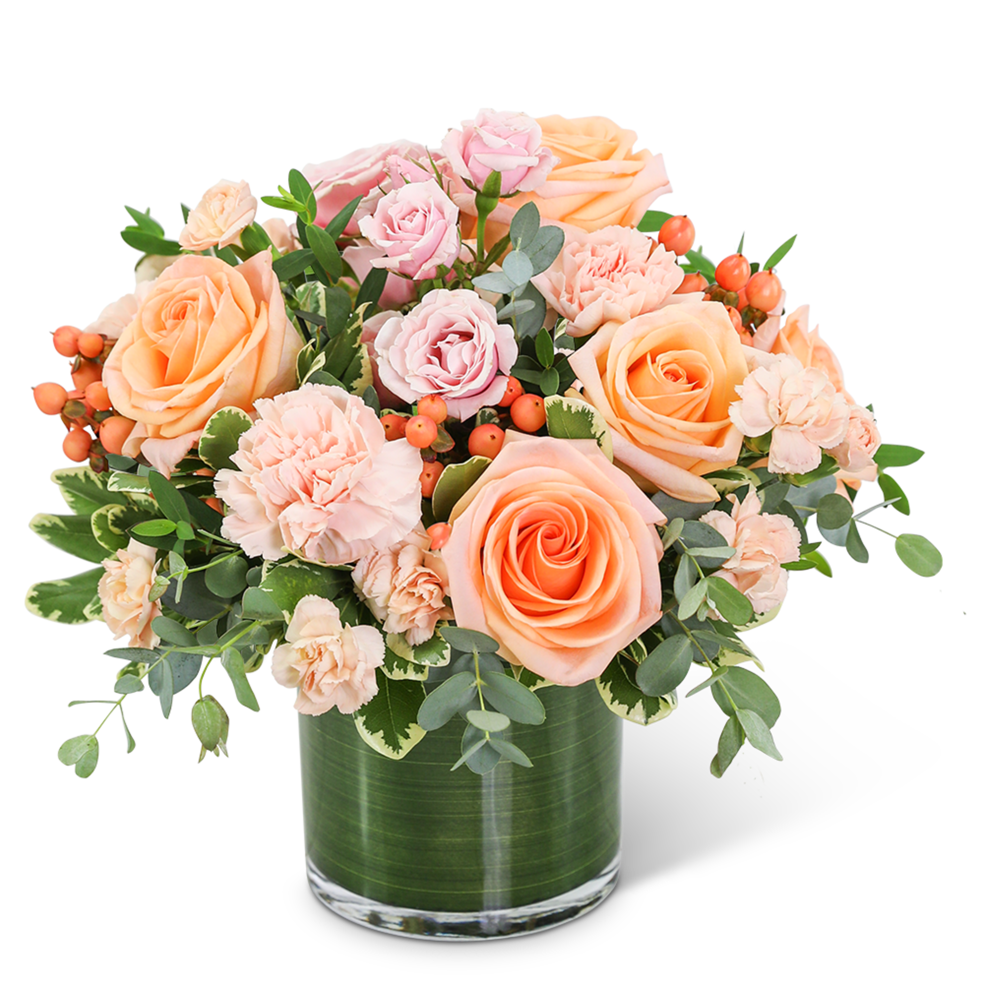 Peach and pink roses with carnations in a glass vase