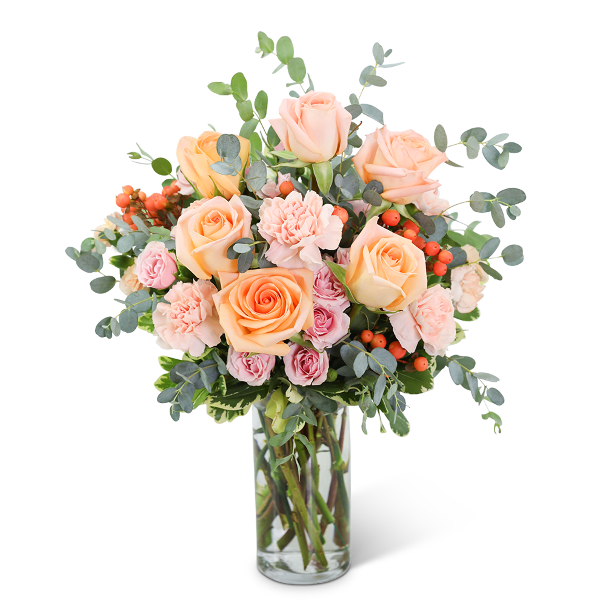 Peach and pink roses in a clear glass vase with eucalyptus