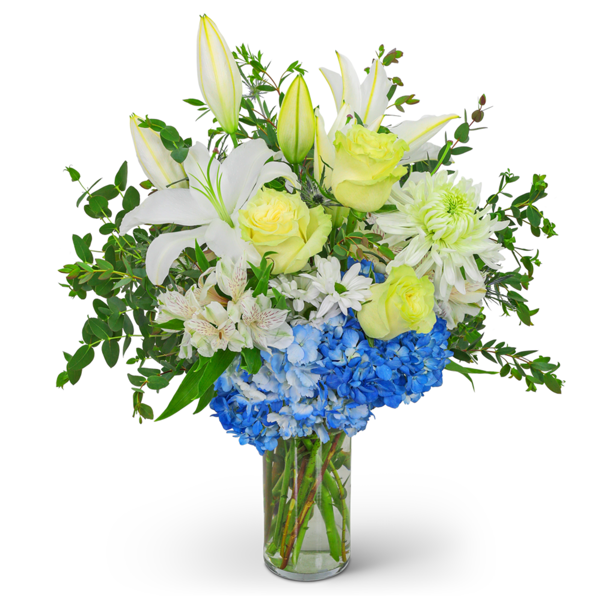 White lilies, yellow roses, and blue hydrangeas in a glass vase