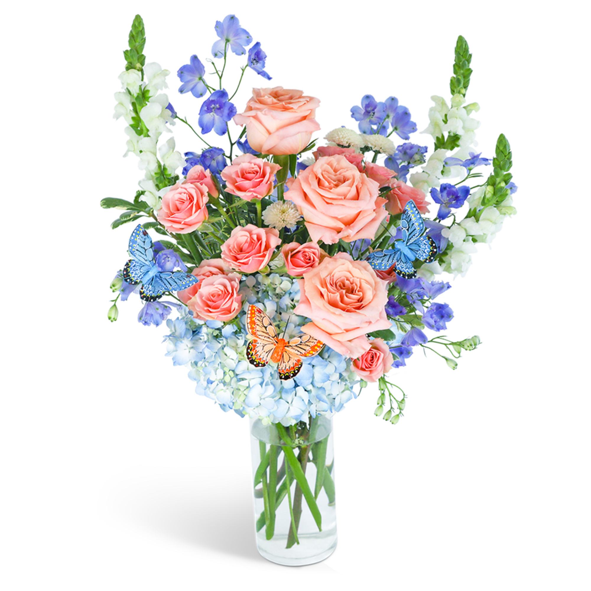 Peach roses and blue flowers in a clear glass vase with butterfly accents